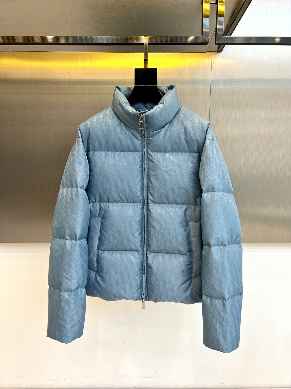 Dio迪奥（白鹅绒）、2025秋冬新品 DIOR羽绒服。浅蓝色短款设计搭配立领结构，通过精密拉链系统实现