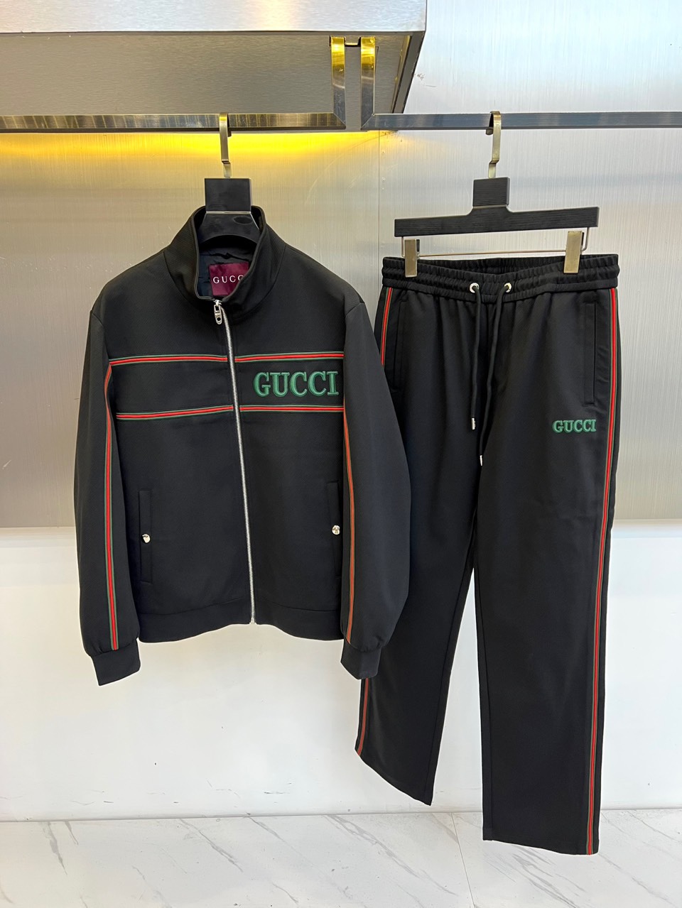 NO:599294,Gucci, the new autumn and winter 2025 suit, interprets modern luxury sports style in all white tones. The suit includes a stand-up collar zipper jacket and a pair of casual trousers of the same color, with a pure and neat overall shape. The classic red and green webbing on the chest of the jacket echoes the stripes on the sleeve side, and is paired with the eye-catching GUCCI letter logo, which instantly enhances brand recognition. The trousers are cut in a loose and comfortable style, and are also decorated with red and green stripes on the sides, forming a clever connection with the top, and the waist  The drawstring design takes into account both leisure and practical functions. This series cleverly combines brand genes and sports aesthetics, and exquisite craftsmanship and high-quality fabrics ensure the wearing experience and high-end texture. Whether it is daily casual or fashionable occasions, this outfit can easily create a modern style that is both energetic and elegant, showing an eclectic fashion attitude. 48-56 (model 173, 143 pounds, upper body size 50),, gucci, gucci, jackets  & coats,alexander wang19860909Gucc古驰、2025秋冬新品套装,以全白色调演绎现代奢华运动风尚.套装包含一件立领拉链外套和一条同色系休闲长裤,整体造型纯净利落.外套胸前的经典红绿织带与袖侧条纹相呼应,搭配醒目的GUCCI字母标识,瞬间提升品牌辨识度.裤装采用宽松舒适的剪裁,侧边同样饰以红绿条纹,与上衣形成巧妙衔接,腰部抽绳设计兼顾休闲感与实用功能.本系列巧妙融合品牌基因与运动美学,精湛工艺与优质面料确保穿着体验与高级质感.无论是日常休闲还是时尚场合,这套装扮都能轻松营造出兼具活力与优雅的摩登型格,展现不拘一格的时尚态度.48-56（模特173,143斤上身50码）,,gucci,gucci,jackets & coats,alexander wang,Men's clothing