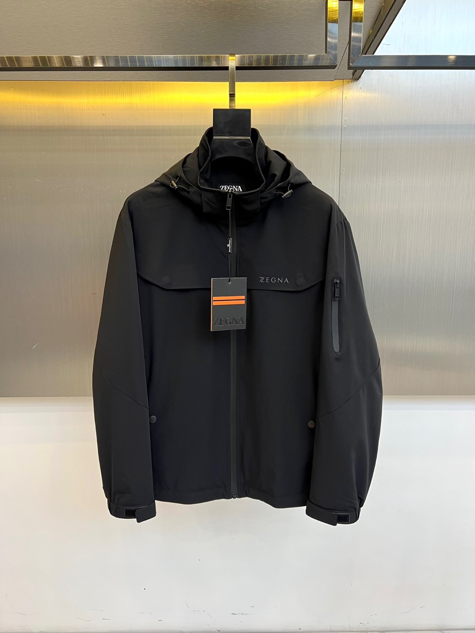 NO:760797,Zegna, the new men's thin cotton windbreaker jacket for autumn and winter 2025, interprets modern urban style with a hooded silhouette with great outdoor functions. The calm brown tone gives the overall simple and elegant visual experience. The body is made of technical polyester fiber fabric, which is crisp and stylish and has excellent windproof protection performance, perfect for autumn and winter weather. The black zipper on the front is smooth and neat, and the practical pockets on the left chest and left arm are designed with ingenuity to meet daily storage needs.  Demand. The shoulders are neatly cut, and the cuffs are equipped with adjustable buckles, demonstrating the brand's precise control of details. The 'ZEGNA' logo on the left chest low-key declares its luxurious pedigree. This jacket perfectly combines outdoor functionality with Italian exquisite aesthetics. Whether walking in the mountains or traveling in the city, it can show a calm and extraordinary gentleman style. 48-56 (model 173, 143 pounds, upper body size 50),,zegna,jackets  & coats,hats,19860909Zegna杰尼亚、2025秋冬新品男士薄棉风衣外套,以极具户外机能的连帽廓形演绎现代都市风尚.沉稳的棕色调赋予整体简约大气的视觉感受.衣身采用科技聚酯纤维面料,挺括有型且具备出色的防风防护性能,完美应对秋冬气候.前襟的黑色拉链顺滑利落,左胸及左臂的实用口袋设计融入巧思,满足日常收纳需求.肩部剪裁利落,袖口配有可调节搭扣,彰显品牌对细节的精准把控.左胸的“ZEGNA”标识低调宣示奢华血统.这款外套将户外功能性与意式精致美学完美结合,无论是山野漫步还是都市穿梭,皆能展现从容不凡的绅士型格.48-56（模特173,143斤上身50码）,,zegna,jackets & coats,hats,,Men's clothing