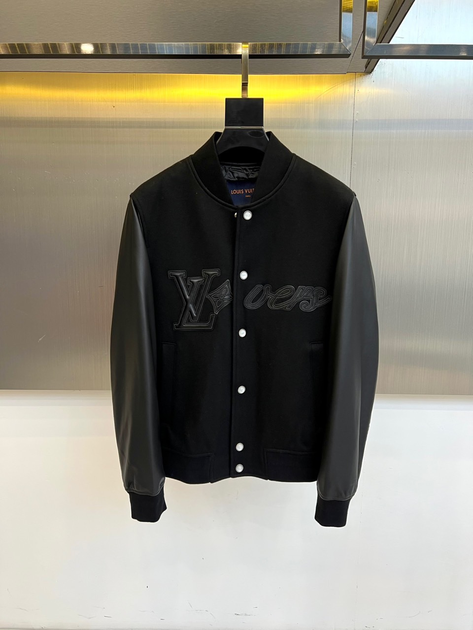 NO:601549,1v Vuitton, this LV  The new jacket for autumn and winter uses a gray and white baseball uniform style to create a simple and highly recognizable appearance. The front of the jacket is embellished with the white LV logo and 'vers' embroidery, highlighting the unique charm of the brand. The sleeves are made of high-grade protein leather, which has a delicate touch and outstanding texture, adding a luxurious atmosphere to the whole. The body is blended with 20 wool fabric, which is not only warm and comfortable, but also suitable for autumn and winter wearing needs. Design  The design perfectly combines the casual vitality of classic baseball uniforms with fashionable luxury. The details such as the collar and pockets are exquisitely processed to ensure that every detail reflects the sense of quality. This jacket is easy to match with a variety of styles of clothing. Whether it is daily travel or fashion gatherings, it can help you show your unique fashion taste and become the highlight of your autumn and winter wardrobe. 48-56 (model 173, 143 pounds, upper body size 50), louis  vuitton,versace,jackets & coats,alexander wang198609091v威登、这款LV 秋冬新品外套以灰白配色的棒球服样式打造出简约而辨识度极高的外观,衣身正面点缀着白色LV标志和“vers”字样刺绣,彰显品牌独特魅力.袖子采用高级蛋白皮材质,触感细腻且质感出众,为整体增添奢华气息；衣身则融入20羊毛面料,不仅保暖舒适,还适合秋冬季节的穿着需求.设计上完美融合了经典棒球服的休闲活力与时尚奢华感,领口和口袋等细节处理精致,确保每一处都体现品质感.这款外套易于搭配多种风格服饰,无论是日常出行还是时尚聚会,都能助您展现独特时尚品味,成为秋冬衣橱的亮点单品.48-56（模特173,143斤上身50码）,,louis vuitton,versace,jackets & coats,alexander wang,Men's clothing