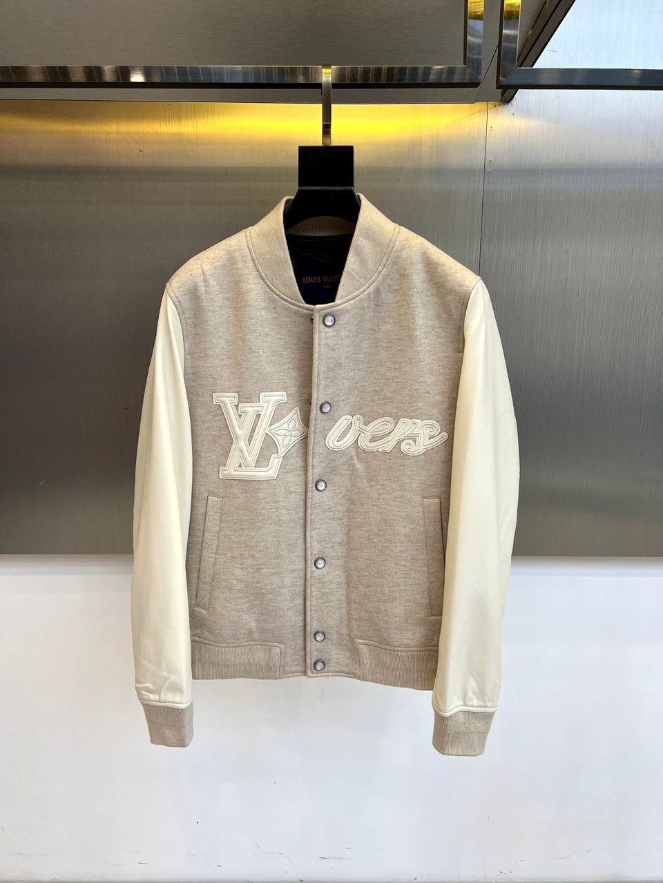 NO:599292,1v Vuitton, this LV  The 2025 autumn and winter new jackets are designed in the style of baseball uniforms with gray and white colors to create a simple and highly recognizable appearance. The front of the jacket is embellished with the white LV logo and 'vers' embroidery, highlighting the brand's unique charm. The sleeves are made of high-grade protein leather, which has a delicate touch and outstanding texture, adding a luxurious atmosphere to the whole. The body is blended with 20 wool fabric, which is not only warm and comfortable, but also suitable for autumn and winter wearing needs.  .The design perfectly combines the casual vitality and fashionable luxury of the classic baseball uniform. The details such as the collar and pockets are exquisitely processed to ensure that every aspect reflects the sense of quality. This jacket is easy to match with a variety of styles of clothing. Whether it is daily travel or fashion gatherings, it can help you show your unique fashion taste and become the highlight of your autumn and winter wardrobe. 48-56 (model 173, 143 pounds, upper body size 50),, louis  vuitton,versace,jackets & coats,alexander wang198609091v威登、这款LV 2025秋冬新品外套以灰白配色的棒球服样式打造出简约而辨识度极高的外观,衣身正面点缀着白色LV标志和“vers”字样刺绣,彰显品牌独特魅力.袖子采用高级蛋白皮材质,触感细腻且质感出众,为整体增添奢华气息；衣身则融入20羊毛面料,不仅保暖舒适,还适合秋冬季节的穿着需求.设计上完美融合了经典棒球服的休闲活力与时尚奢华感,领口和口袋等细节处理精致,确保每一处都体现品质感.这款外套易于搭配多种风格服饰,无论是日常出行还是时尚聚会,都能助您展现独特时尚品味,成为秋冬衣橱的亮点单品.48-56（模特173,143斤上身50码）,,louis vuitton,versace,jackets & coats,alexander wang,Men's clothing