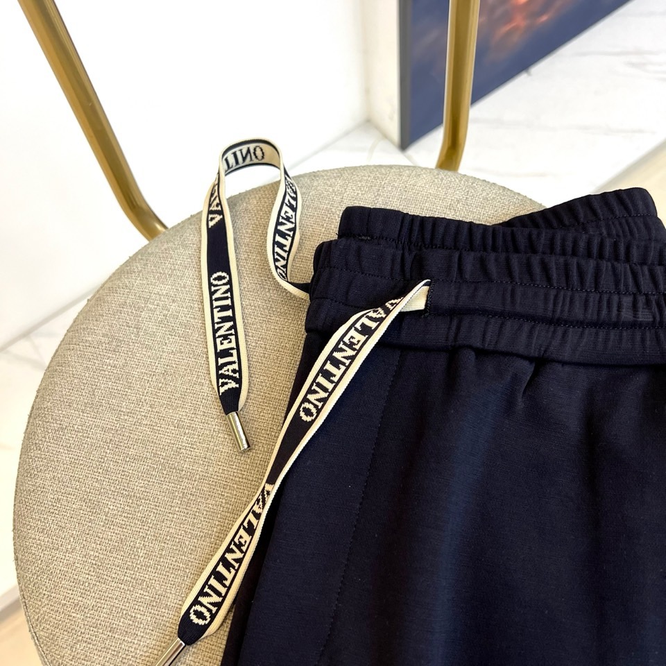 VT华伦天奴、2025秋冬新品风格休闲裤。这款束脚休闲裤采用华伦天奴标志性设计，裤腰配有黑色抽绳并印有白