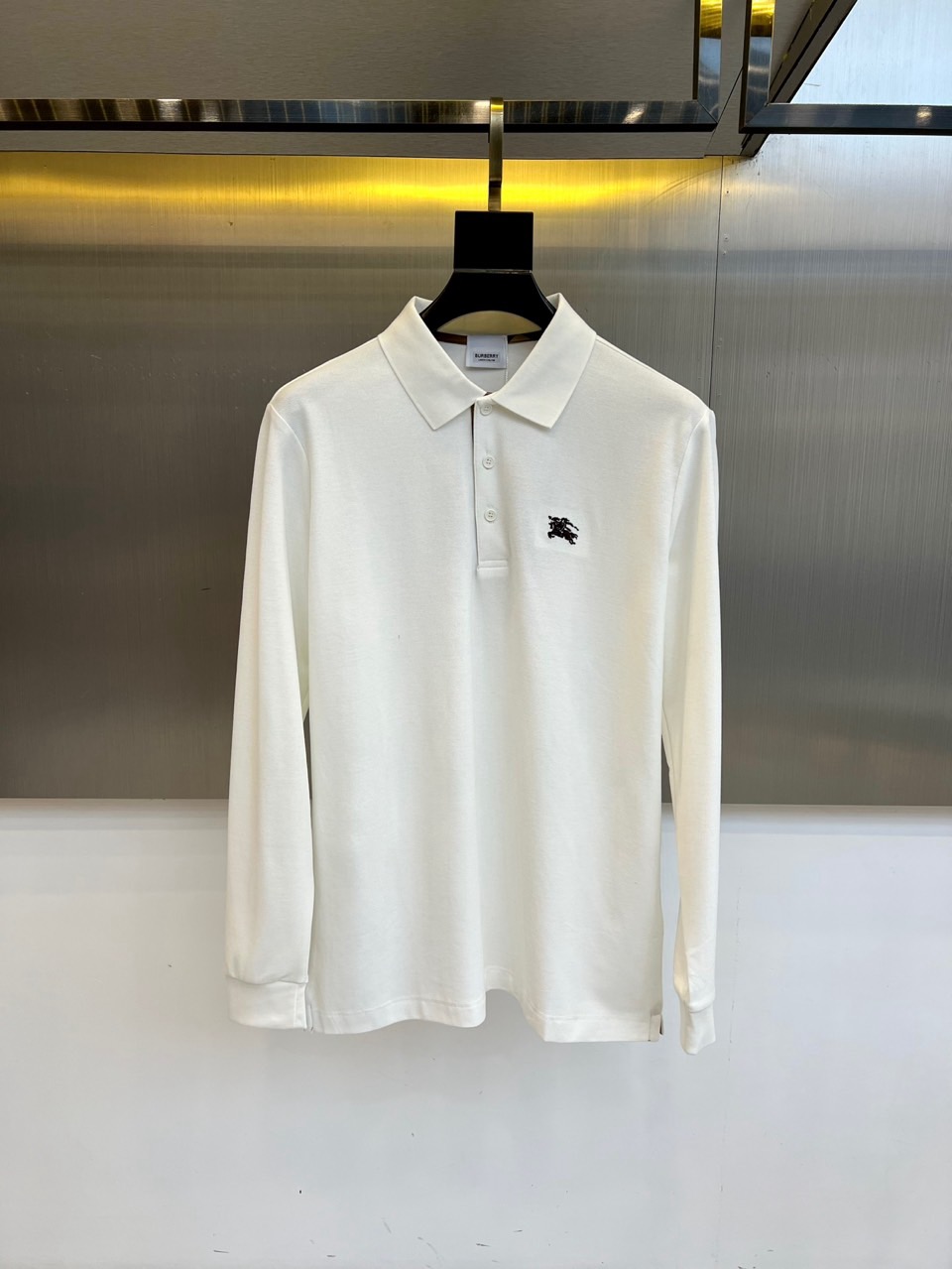 Bur巴宝莉、2025秋冬新品长袖Polo衫，以经典白色演绎英伦优雅美学。这款Polo衫采用高品质棉质面