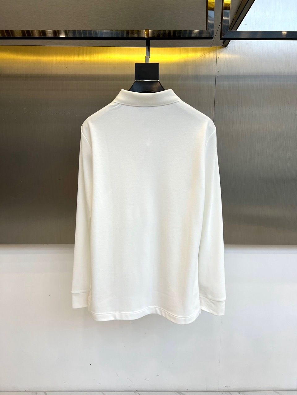 H爱马仕、2025秋冬新品薄绒半拉链翻领长袖上衣，以纯净白色演绎极致简约美学。经典Polo领设计突破传统