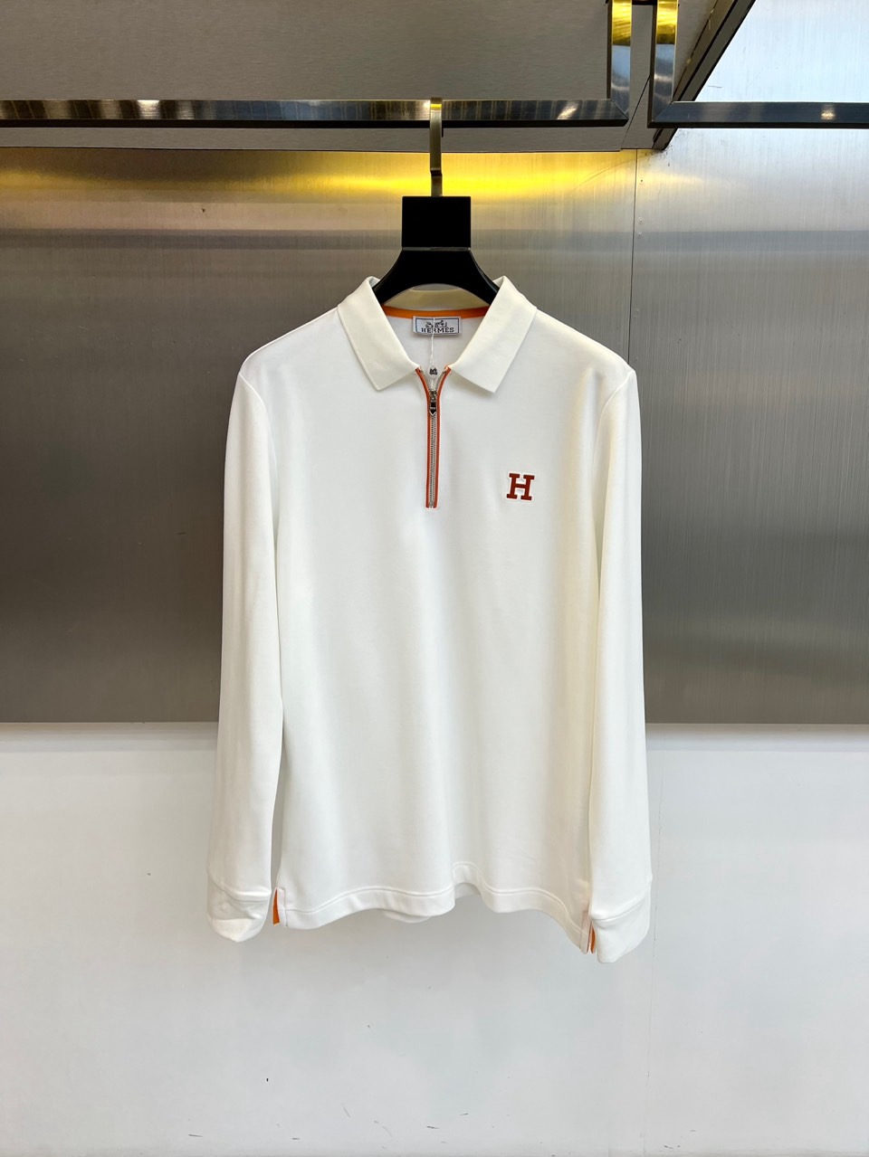H爱马仕、2025秋冬新品薄绒半拉链翻领长袖上衣，以纯净白色演绎极致简约美学。经典Polo领设计突破传统