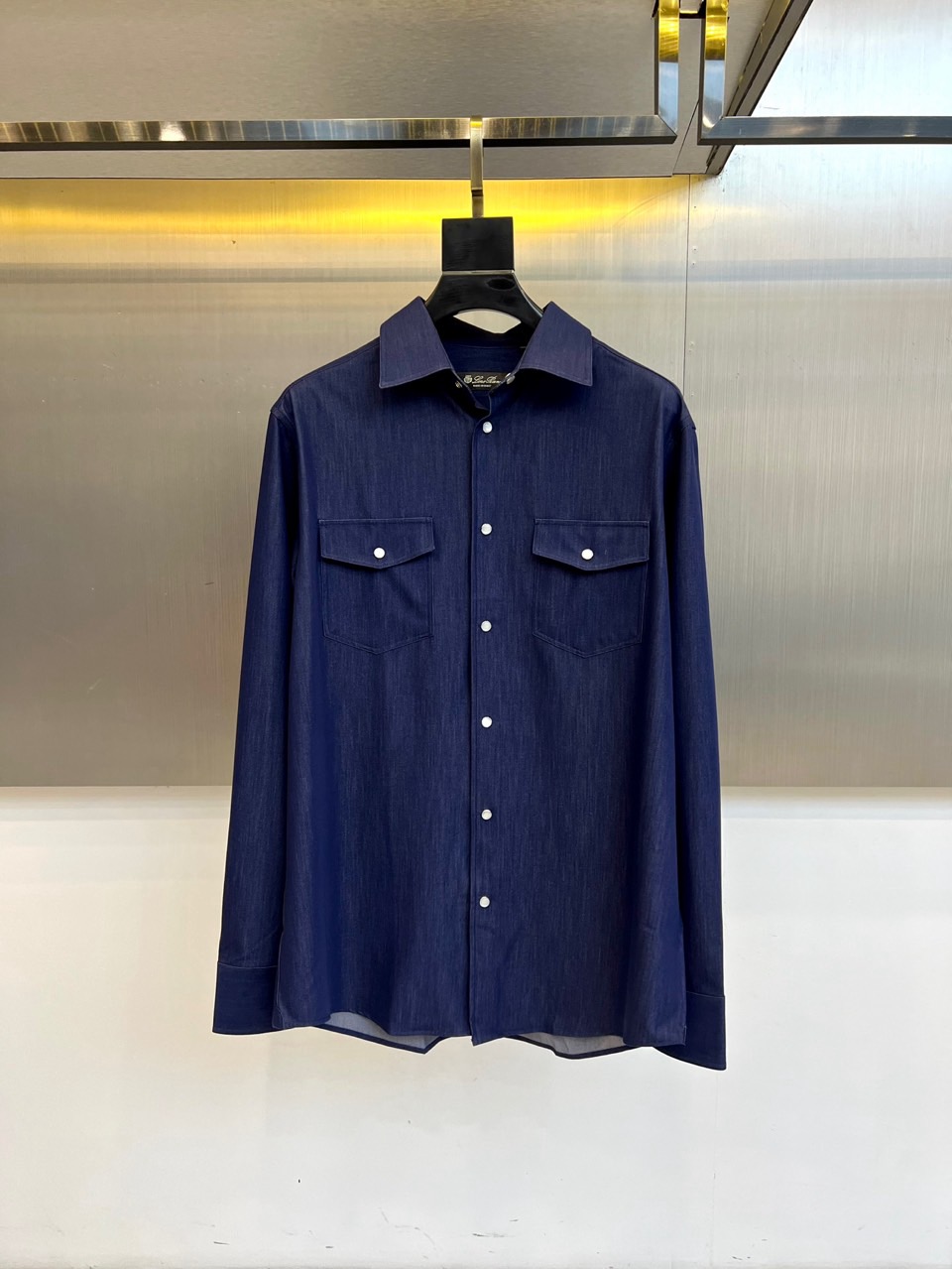 NO:726285,Loro Piana's new autumn and winter shirts are elegant and elegant. This shirt has a classic lapel design, an innovative double-row white button layout on the front, symmetrical flap pockets decorated with buttons of the same color, and a natural leather tag on the right pocket to highlight the brand's genes. The fabric is made of cotton, with a fine twill texture using traditional Italian textile techniques. The sky blue tone is like the clear sky along the Adriatic coast. The slim fit is matched with a precise fit, and the collar and cuffs are padded to maintain a crisp outline.  The double-breasted design not only retains the elegance of formal shirts, but also injects a sense of ease into daily wear. It can be paired with suit pants to create a business image, or it can be paired with casual pants to show a Mediterranean vacation style. Through detailed ingenuity and color aesthetics, it interprets LORO PIANA's design philosophy of integrating Italian craftsmanship with natural inspiration. 48-56 (model 173, 143 pounds, upper body size 50),,loro piana,shirts,business suit,19860909年后 Loro Piana诺悠翩雅、秋冬新品衬衫.这款衬衫采用经典翻领设计,前襟创新运用双排白色纽扣布局,左右对称的带盖口袋以同色纽扣点缀,右侧口袋附有天然皮革吊牌彰显品牌基因.面料选用棉质材质,通过意大利传统纺织工艺呈现细腻斜纹肌理,天空蓝色调宛若亚得里亚海沿岸晴空.修身剪裁配合精准版型,领口与袖口采用加衬工艺保持挺括轮廓. 双排扣设计既保留正装衬衫的优雅,又为日常穿搭注入轻松感.可搭配西装裤塑造商务形象,亦可配合休闲裤展现地中海度假风情.通过细节匠心与色彩美学,诠释LORO PIANA将意式工艺与自然灵感相融合的设计哲学.48-56（模特173,143斤上身50码）,,loro piana,shirts,business suit,,Men's clothing