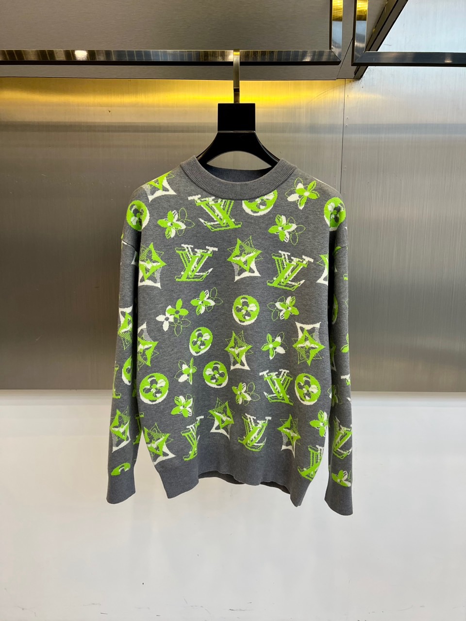 NO:597256,1v Vuitton's new autumn and winter knitted sweaters are based on deep black. The brand's classic orange and gray Monogram presbyopia patterns are artfully reorganized and embellished with romantic floral embroidery to create a retro fashionable item full of visual tension. The round neck design and loose fit give the wearer a lazy and comfortable experience, and the cotton fabric ensures skin-friendly breathability. The fine jacquard craftsmanship gives the presbyopia pattern a three-dimensional texture, with jumping orange and elegant gray on black.  There is a sharp contrast on the background, and the Roman numerals carefully arranged at the hem add hidden and interesting details. This sweater not only continues Louis Vuitton's luxury genes, but also breaks the traditional boundaries through trendy design. Whether it is paired with leather items to show a cool style, or mixed with a silk skirt to create a strong and soft charm, it can become a fashion statement that lights up the autumn and winter look. 48-56 (model is 173, 143 pounds, upper body size 50),, louis  vuitton,skirts,sweaters,alexander wang198609091v威登、秋冬新品针织毛衣,以深邃黑色为底,巧妙将品牌经典橙色与灰色Monogram老花图案进行艺术化重组,并点缀浪漫花卉刺绣,打造出充满视觉张力的复古时髦单品.圆领设计与宽松版型赋予穿着者慵懒舒适的体验,棉质面料确保亲肤透气性.精细的提花工艺让老花图案呈现立体质感,跳跃的橙色与优雅的灰色在黑色背景上形成鲜明对比,衣摆处精心排列的罗马数字暗纹则增添隐秘的趣味细节.这件毛衣既延续了路易威登的奢华基因,又通过潮流化设计打破传统边界,无论是搭配皮革单品展现飒爽型格,还是与丝质半裙混搭营造刚柔并济的魅力,都能成为点亮秋冬造型的时尚宣言.48-56（模特173,143斤上身50码）,,louis vuitton,skirts,sweaters,alexander wang,Men's clothing