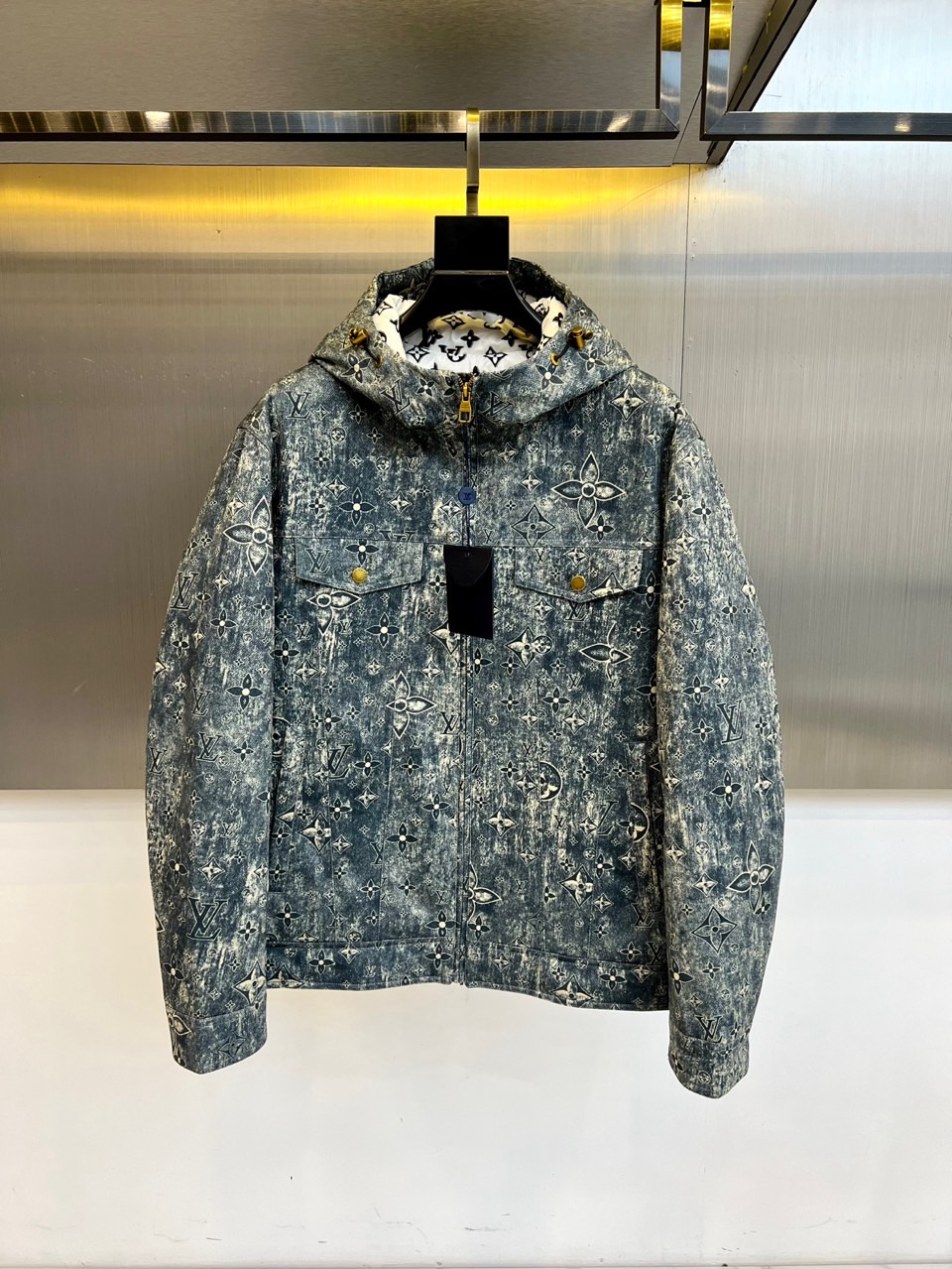 NO:596150,1v Vuitton, the new hooded down jacket for autumn and winter 2025, interprets the classic Monogram presbyopia pattern in gray and blue tones. The fabric is treated with distressed technology, showing a unique retro texture, and the brand logo is fully printed on the inside of the hood to show the craftsmanship of details. This product is filled with 90% high-quality duck down, and the amount of down is accurately configured from 150g to 205g according to different sizes. It has both a light texture and excellent thermal performance.  The style design combines pragmatism and fashion aesthetics. It is equipped with a smooth zipper closure on the front, oblique pockets on both sides decorated with gold buttons and black leather patches, and elastic edge design on the cuffs and hem to enhance wind resistance. The three-dimensional and close-fitting tailoring ensures freedom of movement while perfectly avoiding the bloated feeling common in down items.  Its style perfectly balances street trends and high-end fashion. The old flower elements break the boundaries of traditional luxury. The gray and blue tones give the item a calm and high-end visual expression. Whether it is paired with urban formal wear or casual wear, this down jacket can be the finishing touch of the overall look. It meets both the need for warmth and fashion expression in the cold season, redefining the new standard for outdoor luxury clothing in winter. 48-56 (model 173, 143 pounds, upper body size 50), jackets & coats, down  jacket,hats,alexander wang198609091v威登、2025秋冬新品连帽羽绒夹克,以灰蓝色调演绎经典Monogram老花图案.面料采用做旧工艺处理,呈现出独特的复古质感,连帽内侧亦满印品牌标识彰显细节匠心.本品填充90优质鸭绒,根据尺码不同绒量精准配置150克至205克,兼具轻盈质感与卓越保暖性能. 款式设计融合实用主义与时尚美学正面配置顺滑拉链开合,两侧斜插口袋装饰金色纽扣与黑色皮质贴片,袖口及下摆采用弹力收边设计增强防风性.立体贴身的剪裁在保证活动自如的同时,完美规避羽绒单品常见的臃肿感. 其风格完美平衡街头潮流与高端时尚,做旧老花元素打破传统奢华边界,灰蓝色调赋予单品沉稳高级的视觉表现.无论是搭配都市正装还是休闲服饰,这件羽绒夹克都能成为整体造型的点睛之笔,在寒冷季节同时满足保暖需求与时尚表达,重新定义冬季户外奢华着装新标准.48-56（模特173,143斤上身50码）,,jackets & coats,down jacket,hats,alexander wang,Men's clothing