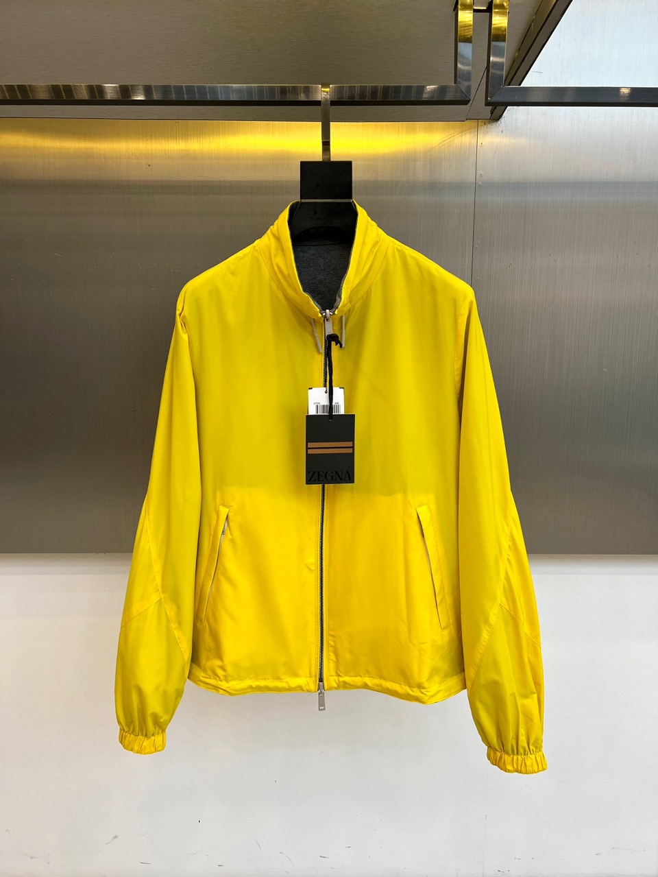 NO:596154,ZEGNA, the new 2025 autumn and winter reversible jacket, interprets Italian gentleman aesthetics with innovative design. The style adopts a neat stand-up collar design, with a smooth zipper opening and closing system, and practical diagonal pockets on both sides. One side uses a calm gray tone to present a low-key business feel, and the other side uses bright yellow to inject modern vitality. The double-sided wearable design enables free switching of styles. The left chest is embellished with the brand logo badge, and the cuffs are precision-edged to ensure a neat fit.  The fabric is made of top technical materials, with the gray side showing a delicate texture and the yellow side using high-count fabric to ensure lightness and breathability. Its tailoring uses three-dimensional splicing technology to optimize body lines. It can be paired with a white business shirt to show an elite style, or it can be combined with a casual sweater for a fun mix and match. From business meetings to weekends  For travel, this jacket combines the practical philosophy of double-sided wear with the fashionable ingenuity of color collision, becoming a carrier that connects Italian ingenuity and contemporary life, interpreting ZEGNA's new definition of gentleman's clothing. S-XXL (model 173,143 pounds, upper body size M),,zegna,jackets  & coats,shirts,alexander wang19860909ZEGNA杰尼亚、2025秋冬新品双面穿夹克,以创新设计诠释意式绅士美学.款式采用利落立领设计,搭配顺滑拉链开合系统,两面均设有实用斜插口袋.一面采用沉稳灰色调呈现低调商务感,另一面以明亮黄色注入现代活力,通过双面可穿设计实现风格自由切换.左胸点缀品牌标识徽章,袖口采用精准收边工艺确保穿着利落感. 面料选用顶级技术材质,灰色面呈现细腻肌理质感,黄色面采用高支面料确保轻盈透气性.其剪裁通过立体拼接技术优化身形线条,可搭配白色商务衬衫展现精英风范,亦可与休闲针织衫碰撞出混搭趣味.从商务会议到周末出行,这款夹克以双面穿着的实用哲学与色彩碰撞的时尚巧思,成为连接意式匠心与当代生活的载体,诠释ZEGNA对绅士着装的全新定义.S-XXL（模特173,143斤上身M码）,,zegna,jackets & coats,shirts,alexander wang,Men's clothing