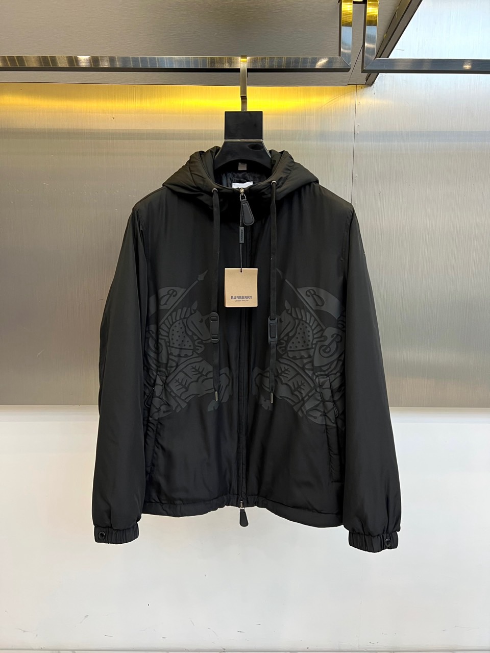 NO:596156,Burberry, 2025 autumn and winter new black hooded cotton jacket, interprets modern urban style with the brand's iconic aesthetics. The style adopts a hooded design with an adjustable drawstring, the placket is equipped with a smooth zipper opening and closing system, and practical pockets on both sides are integrated into three-dimensional tailoring.  Craftsmanship. The body is decorated with embossed decorations of the brand's classic patterns, and exquisite texture levels are presented through exquisite craftsmanship. The fabric is strictly made of polyester fiber, and the filling is polyester fiber filling to ensure light and warm performance; the lining is made of cupro fiber, giving the clothing a smooth and skin-friendly touch  It feels. Its three-dimensional tailoring optimizes body lines through precise silhouette. It can be paired with casual trousers to create a daily look, or it can be combined with formal items to create a fun mix and match. From urban commuting to weekend trips, this jacket uses a balance of technical fabrics and practical details to become a fashion carrier that connects century-old heritage and contemporary life, interpreting Burberry's in-depth exploration of elegant practical aesthetics. S-XXL (model 173, 143 pounds, upper body size M),, burberry, burberry, jackets  & coats,jackets & coats,hats,alexander wang19860909Bur巴宝莉、2025秋冬新品黑色连帽棉服夹克外套,以品牌标志性美学演绎现代都市风尚.款式采用连帽设计搭配可调节抽绳,门襟配置顺滑拉链开合系统,两侧实用口袋融入立体剪裁工艺.衣身饰有品牌经典图案浮雕装饰,通过精湛工艺呈现细腻纹理层次.面料严格选用聚酯纤维材质,填充物为聚酯纤维填充,确保轻盈保暖性能；衬里采用铜氨纤维,赋予衣物柔滑亲肤触感.其立体剪裁通过精准版型优化身形线条,可搭配休闲长裤打造日常造型,亦可与正装单品碰撞出混搭趣味.从城市通勤到周末出行,这款外套以科技面料与实用细节的平衡,成为连接百年传承与当代生活的时尚载体,诠释Burberry对优雅实穿美学的深度探索.S-XXL（模特173,143斤上身M码）,,burberry,burberry,jackets & coats,jackets & coats,hats,alexander wang,Men's clothing