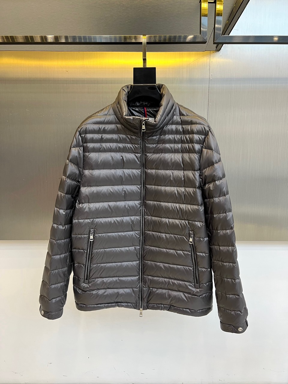 NO:596158,Mon (pure goose down), the 2025 autumn and winter new down jacket uses dark gray tones to interpret modern minimalist aesthetics. The stand-up collar design is matched with silver zipper opening and closing. The body is neatly geometrically divided through precise horizontal quilting technology to enhance the stability of the filling.  It has a three-dimensional silhouette. The diagonal pockets on both sides are equipped with zippers of the same color, and the cuffs are embellished with practical button details. The fabric is strictly made of polyamide, which has excellent windproof performance; the filling is clearly marked as 90 pure goose down, strictly complying with EU EN12934 down  Standard, ensuring a light and fluffy warmth experience. Its cut is neat and crisp, and it can be paired with trousers of the same color to enhance the overall look. It can also collide with casual items to create a mixed style. From urban commuting to outdoor activities, this down jacket combines the unique texture of horizontal quilting with pure goose  The excellent performance of velvet has become a winter model that connects high-end craftsmanship and practical functions, interpreting Moncler's dual pursuit of materials and silhouettes. Sizes 1-5 (model weighs 173,143 pounds, upper body size 2),,Moncler,down  jacket,alexander wang19860909Mon蒙口（纯鹅绒）、2025秋冬新品羽绒服以深灰色调演绎现代极简美学,立领设计搭配银色拉链开合,衣身通过精准的横向绗缝工艺形成整齐的几何分割,增强填充物的稳定性与立体轮廓感.两侧斜插口袋配备同色拉链,袖口点缀实用纽扣细节.面料严格选用聚酰胺材质,具备出色防风性能；填充物明确标注为90纯鹅绒,严格执行欧盟EN12934羽绒标准,确保轻盈蓬松的保暖体验.其剪裁利落挺括,可搭配同色系裤装强化整体感,亦能与休闲单品碰撞出混搭风格.从都市通勤到户外活动,这款羽绒服以横向绗缝的独特肌理与纯鹅绒的卓越性能,成为连接高端工艺与实用功能的冬季典范,诠释Moncler对材质与廓形的双重追求.1-5码（模特173,143斤上身2码）,,Moncler,down jacket,alexander wang,Men's clothing