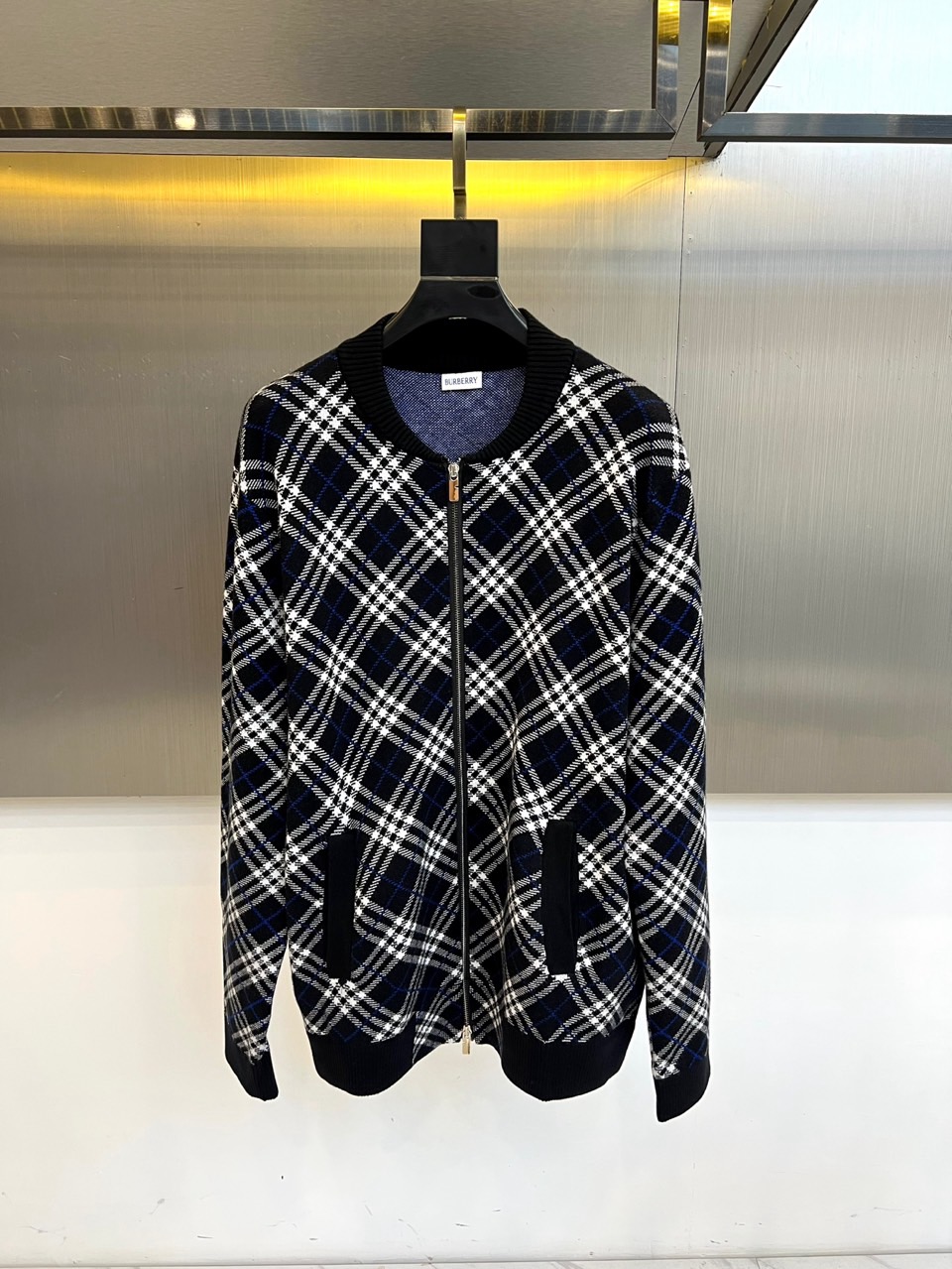 NO:596175,Burberry, the new plaid wool jacket for autumn and winter 2025, uses the brand's iconic black, white and blue plaid to interpret modern British style. The style adopts a neat short cut, with a smooth metal zipper opening and closing system, and ribbed knitted stand-up collar and cuffs to enhance windproof practicality.  . There are diagonal pockets on both sides of the body. The blended fabric of 87 wool and 7 mohair presents a delicate texture. 5 nylon and 1 spandex are added to improve wear resistance and elasticity. Romanian precision manufacturing ensures the accuracy of every stitching, and the 94 wool trim continues the brand's dedication to details.  Its design combines traditional plaid genes with urban practicality. It can be paired with trousers of the same color to enhance the overall look, or it can be combined with denim items to create a fun mix and match. From business meetings to weekend trips, this jacket balances the eternal charm of classic plaid with modern tailoring, becoming a fashion carrier that connects century-old heritage and contemporary life, interpreting Burberry's in-depth exploration of material craftsmanship and practical aesthetics. S-XXL (model 173, 143 pounds, upper body size M),, burberry, burberry, jackets &  coats,alexander wang19860909Bur巴宝莉、2025秋冬新品格纹羊毛夹克,以品牌标志性黑白蓝三色格纹演绎现代英伦风尚.款式采用利落短款剪裁,搭配顺滑金属拉链开合系统,罗纹针织立领与袖口增强防风实用性.衣身两侧设斜插口袋,87羊毛与7马海毛混纺面料呈现细腻肌理感,5锦纶与1氨纶添加提升耐磨度与弹性.罗马尼亚精工制造确保每处缝线精准度,94羊毛饰边延续品牌对细节的执着. 其设计将传统格纹基因与都市实穿性相融合,可搭配同色系裤装强化整体感,亦可与牛仔单品碰撞出混搭趣味.从商务会谈到周末出行,这款夹克以经典格纹的永恒魅力与现代剪裁的平衡,成为连接百年传承与当代生活的时尚载体,诠释Burberry对材质工艺与实用美学的深度探索.S-XXL（模特173,143斤上身M码）,,burberry,burberry,jackets & coats,alexander wang,Men's clothing