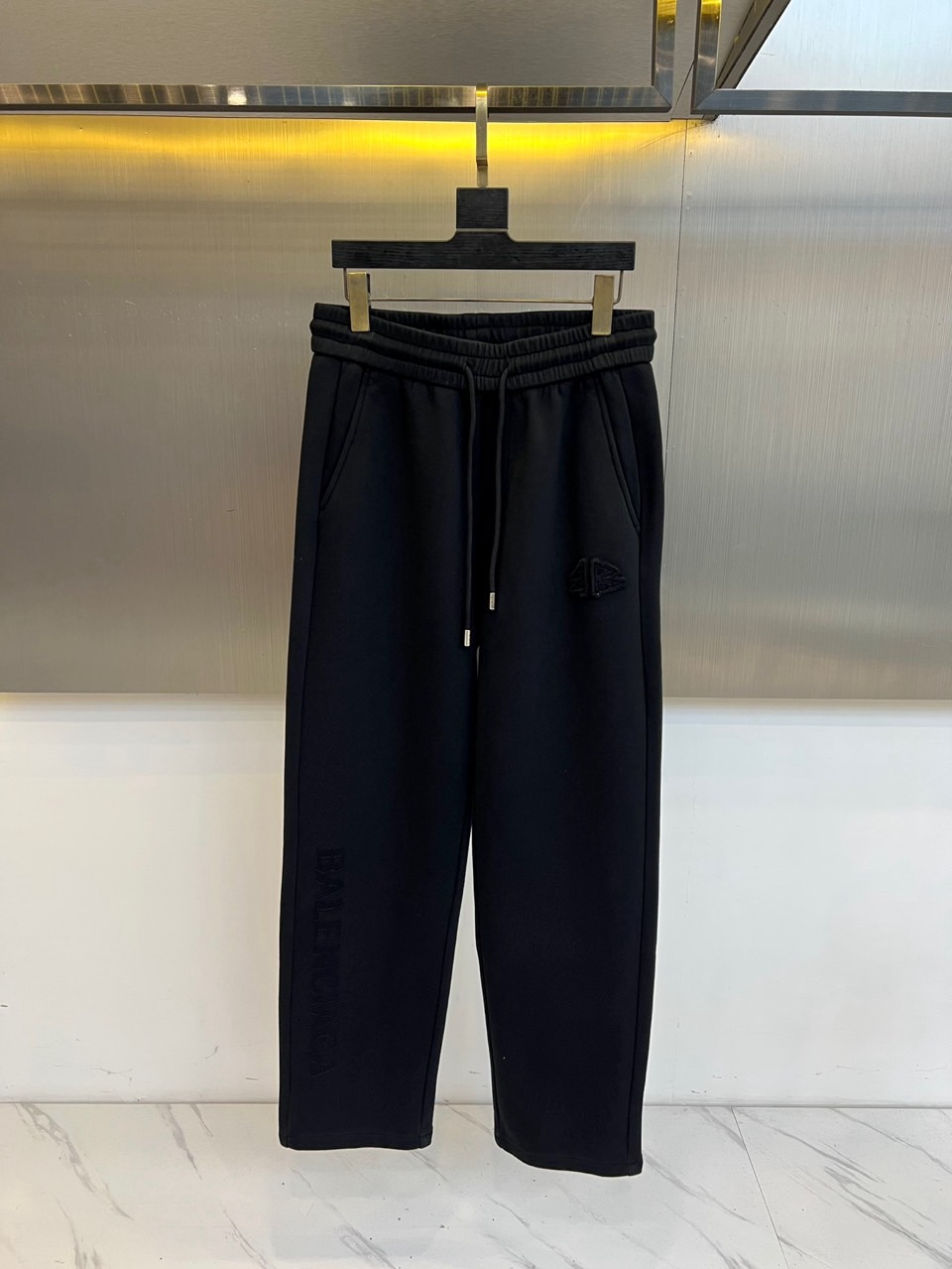 NO:599693,Balenciaga, new black casual pants for autumn and winter, reshape street aesthetics with a loose silhouette. The style adopts a high-waisted design with an adjustable drawstring waistband. The brand's iconic printed logo is decorated on both sides of the pants, and three-dimensional tailoring is reserved at the knees to reserve room for movement. The fabric is made of high-tech cotton blend material, which is both soft and skin-friendly and stiff. Its design combines deconstruction and practicality, and can be matched with oversized  Sweatshirts enhance street style, and can also be combined with leather boots to create a mixed and matched level. From city strolls to night parties, these trousers, with their signature print and loose tailoring, have become a carrier that connects high fashion genes and youth culture, interpreting Balenciaga's breakthrough exploration of contemporary dressing rules.. M-4XL (please state your height and weight when placing an order),,balenciaga,versace,boots,hoodie,sweatshirts,alexander wang19860909Balenciaga、秋冬新品黑色休闲裤,以宽松廓形重塑街头美学.款式采用高腰设计搭配可调节抽绳腰头,裤身两侧饰有品牌标志性印花徽标,膝盖处通过立体剪裁预留活动空间.面料选用高科技棉质混纺材质,兼具柔软亲肤感与挺括度.其设计将解构主义与实穿性相融合,可搭配 oversized 卫衣强化街头风格,亦可与皮革靴款碰撞出混搭层次.从城市漫步到夜间派对,这款长裤以标志性印花与宽松剪裁的平衡,成为连接高级时装基因与青年文化的载体,诠释Balenciaga对当代着装规则的突破性探索..M-4XL（下单请报身高体重）,,balenciaga,versace,boots,hoodie,sweatshirts,alexander wang,Men's clothing