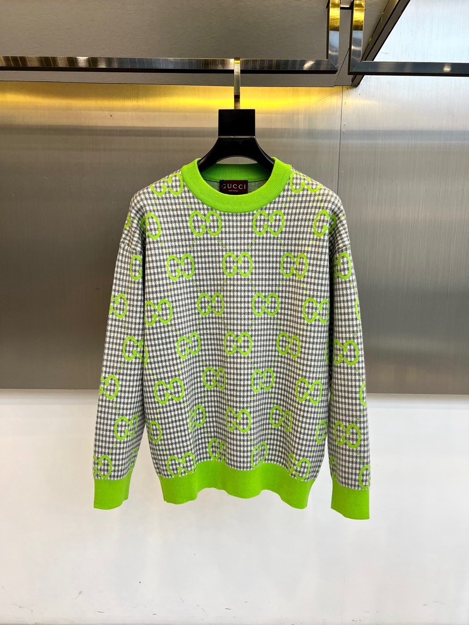 NO:597481,GUCC Gucci's 2025 autumn and winter new round-neck sweater combines retro plaid with modern colors to interpret Italian romantic aesthetics. The style adopts a loose-fitting design, with a gray and white fine plaid as the base, and a forest green double G logo pattern all over. The collar, cuffs and hem are decorated with eye-catching green ribbing, forming a sharp color contrast. The fabric is strictly made of cotton to ensure skin-friendly breathability, and the decorative pattern is made of polyester fiber to enhance the durability of the pattern. Made in Italy guarantees precision workmanship.  Its design combines the brand's classic genes with street style. It can be paired with black leather pants to enhance the retro fashion sense, or it can be combined with a skirt to create a fun mix and match. From fashion parties to daily outings, this sweater has the eternal charm of the double G pattern and the visual impact of green and white colors. It has become a must-have item for autumn and winter that connects brand heritage and trend expression, interpreting the G  UCCI's contemporary reconstruction of classic elements. The washing label clearly indicates the need to wash inside out, avoid chlorine bleaching and tumble drying, and iron at low temperatures not exceeding 48-56 (model is 173,143 pounds, upper body 50?),, gucci, gucci, skirts, sweaters, alexander  wang19860909GUCC古驰、2025秋冬新品圆领毛衣,以复古格纹碰撞现代色彩演绎意式浪漫美学.款式采用宽松版型设计,衣身以灰白细格纹为基底,满铺森林绿色双G标志图案,领口、袖口及下摆饰有醒目的绿色罗纹收边,形成鲜明色彩对比.面料严格选用棉质材质确保亲肤透气性,装饰图案部分采用聚酯纤维材质提升图案持久度,意大利制造保障精工品质. 其设计将品牌经典基因与街头风格相融合,可搭配黑色皮裤强化复古时髦感,亦可与半裙碰撞出混搭趣味.从时尚派对到日常出街,这款毛衣以双G图案的永恒魅力与绿白配色的视觉冲击力,成为连接品牌传承与潮流表达的秋冬必备单品,诠释GUCCI对经典元素的当代重构.洗涤标签明确提示需反面洗涤,避免氯漂与滚筒烘干,低温熨烫不超过度.48-56（模特173,143斤上身50吗）,,gucci,gucci,skirts,sweaters,alexander wang,Men's clothing