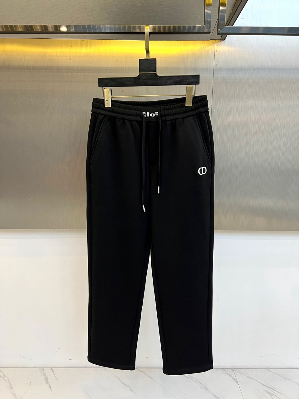 NO:597464,Christian Dior  Dior, 2025 autumn and winter new black sweatpants, interprets French casual aesthetics with a minimalist design. The style adopts three-dimensional tailoring with an elastic drawstring waistband, diagonal pockets on both sides are integrated with invisible stitching technology, and the left trouser leg is embellished with a delicate white 'DIOR' logo. The fabric is made of high-tech cotton blend material, which is both soft and skin-friendly and stiff, and the trousers are slightly cinched to optimize the leg lines. Its design combines luxury genes with street style, and can be worn with a sweatshirt.  Create a casual look, and can also be combined with a leather jacket to create a mixed and matched layer. From daily outings to weekend socializing, this pair of sweatpants has become a carrier that connects high fashion and lifestyle with its iconic logo and practical details, interpreting Dior's in-depth exploration of modern dress aesthetics. 48-56 (model 173,143 pounds, upper body size 50),, dior, dior, hoodie, sweatshirts, jackets  & coats,alexander wang19860909Christian Dior 迪奥、2025秋冬新品黑色卫裤,以极简设计演绎法式休闲美学.款式采用立体剪裁搭配弹性抽绳腰头,两侧斜插口袋融入隐形缝线工艺,左裤腿点缀精致白色'DIOR'标识.面料选用高科技棉质混纺材质,兼具柔软亲肤感与挺括度,裤脚采用微收口设计优化腿部线条.其设计将奢华基因与街头风格相融合,可搭配卫衣打造休闲造型,亦可与皮革外套碰撞出混搭层次.从日常出街到周末社交,这款卫裤以标志性标识与实用细节的平衡,成为连接高级时装与生活方式的载体,诠释迪奥对现代着装美学的深度探索.48-56（模特173,143斤上身50码）,,dior,dior,hoodie,sweatshirts,jackets & coats,alexander wang,Men's clothing