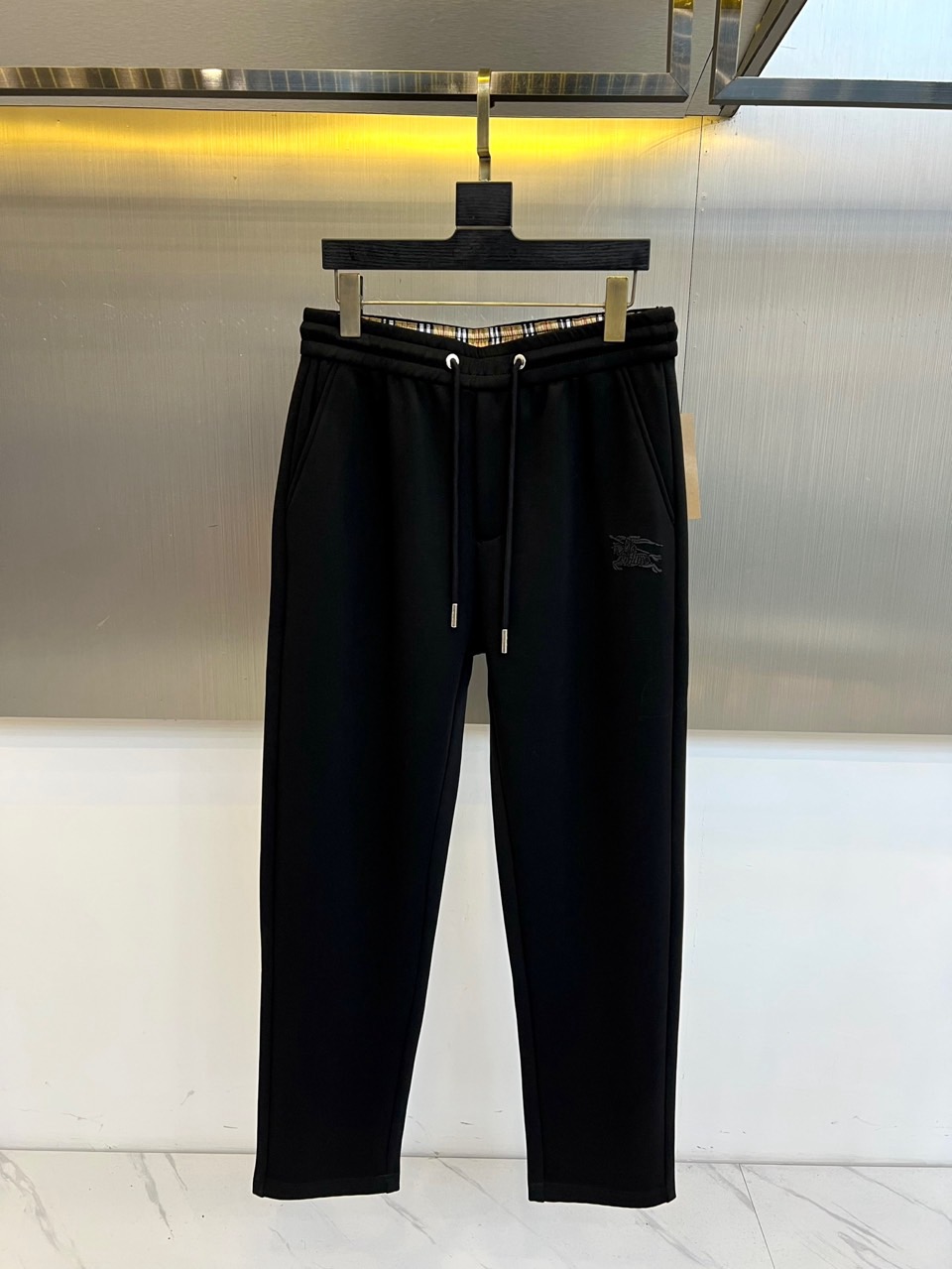 NO:597470,Burberry, the new sports pants for autumn and winter 2025, use modal air layer fabric to reshape the casual aesthetics. The style adopts three-dimensional tailoring with elastic drawstring waistband, diagonal pockets on both sides are integrated with invisible stitching technology, and the brand's iconic embroidered logo is decorated on the side of the pants. The fabric is made of innovative modal air layer material, which is formed with a breathable and thermal insulation structure through special weaving technology. The lining continues the classic plaid pattern to continue the brand gene. Its design combines British tradition with sports functions, and can be paired with a sweatshirt to create an urban leisurely.  The casual style can also be combined with a knitted sweater to create a mixed and matched layer. From daily outings to short trips, these trousers, with the comfortable experience of air-layer fabric and exquisite embroidery details, have become a carrier connecting century-old genes and modern life, interpreting Burberry's contemporary interpretation of practical aesthetics. 48-56 (model is 173,143 pounds and 50 upper body),, burberry, burberry, hoodie, sweatshirts, alexander  wang19860909Bur巴宝莉、2025秋冬新品运动裤,以莫代尔空气层面料重塑休闲美学.款式采用立体剪裁搭配弹性抽绳腰头,两侧斜插口袋融入隐形缝线工艺,裤身侧面饰有品牌标志性刺绣徽标.面料选用创新莫代尔空气层材质,通过特殊织造技术形成透气保温结构,内衬延续经典格纹图案延续品牌基因.其设计将英伦传统与运动功能相融合,可搭配卫衣打造都市休闲造型,亦可与针织衫碰撞出混搭层次.从日常出街到短途出行,这款长裤以空气层面料的舒适体验与精致刺绣细节,成为连接百年基因与现代生活的载体,诠释Burberry对实用美学的当代解读.48-56（模特173,143斤上身50吗）,,burberry,burberry,hoodie,sweatshirts,alexander wang,Men's clothing
