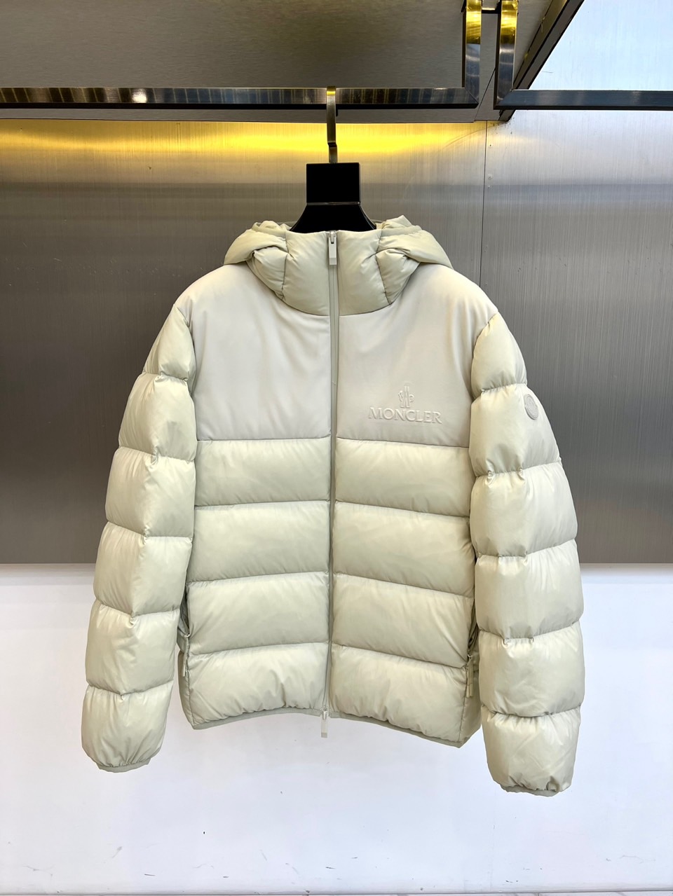 NO:597482,MONCLER Meng Mouth (Pure Goose Down), 2025 Autumn and Winter New Down Jacket. The style adopts a hooded design with smooth zipper opening and closing. The body adopts a precise horizontal quilting process to form a three-dimensional geometric texture to ensure that 90 pure goose down is evenly distributed. The left chest is embellished with the brand's iconic embroidered badge, and the right sleeve is decorated with a circular logo to continue the brand's genes. The fabric is strictly made of polyamide windproof material, and has passed EU EN12934, the United States USA- and Japan JIS  L1903: 2011 triple international certification. The lining is made of polyester fiber to ensure a skin-friendly experience. Its tailoring takes into account both fluffiness and slim silhouette. It can be paired with bottoms of the same color to enhance the overall look. It can also be combined with denim items to create a mixed layer.  From urban commuting to walking in the snow, this down jacket has become a winter model that connects alpine genes and daily fashion with the visual tension of horizontal quilting and professional down quality. The label details highlight the brand's strict pursuit of material standards and interpret MONCLER's craftsmanship in balancing functionality and aesthetics. Sizes 1-5 (model 173,143 pounds upper body size 2),, Moncler, down jacket, hats, alexander wang19860909MONCLER 蒙口（纯鹅绒）、2025秋冬新品羽绒服,款式采用连帽设计搭配顺滑拉链开合,衣身通过精准的横向绗缝工艺形成立体几何纹理,确保90纯鹅绒均匀分布.左胸点缀品牌标志性刺绣徽章,右袖饰有圆形标识延续品牌基因. 面料严格选用聚酰胺防风材质,通过欧盟EN12934、美国USA-及日本JIS L1903:2011三重国际认证,衬里采用聚酯纤维确保亲肤体验.其剪裁兼顾蓬松度与修身轮廓,可搭配同色系下装强化整体感,亦能与牛仔单品碰撞出混搭层次. 从都市通勤到雪地漫步,这款羽绒服以横向绗缝的视觉张力与专业羽绒品质,成为连接高山基因与日常时尚的冬季典范.标签细节彰显品牌对材质标准的严苛追求,诠释MONCLER对功能与美学平衡的匠心精神.1-5码（模特173,143斤上身2码）,,Moncler,down jacket,hats,alexander wang,Men's clothing
