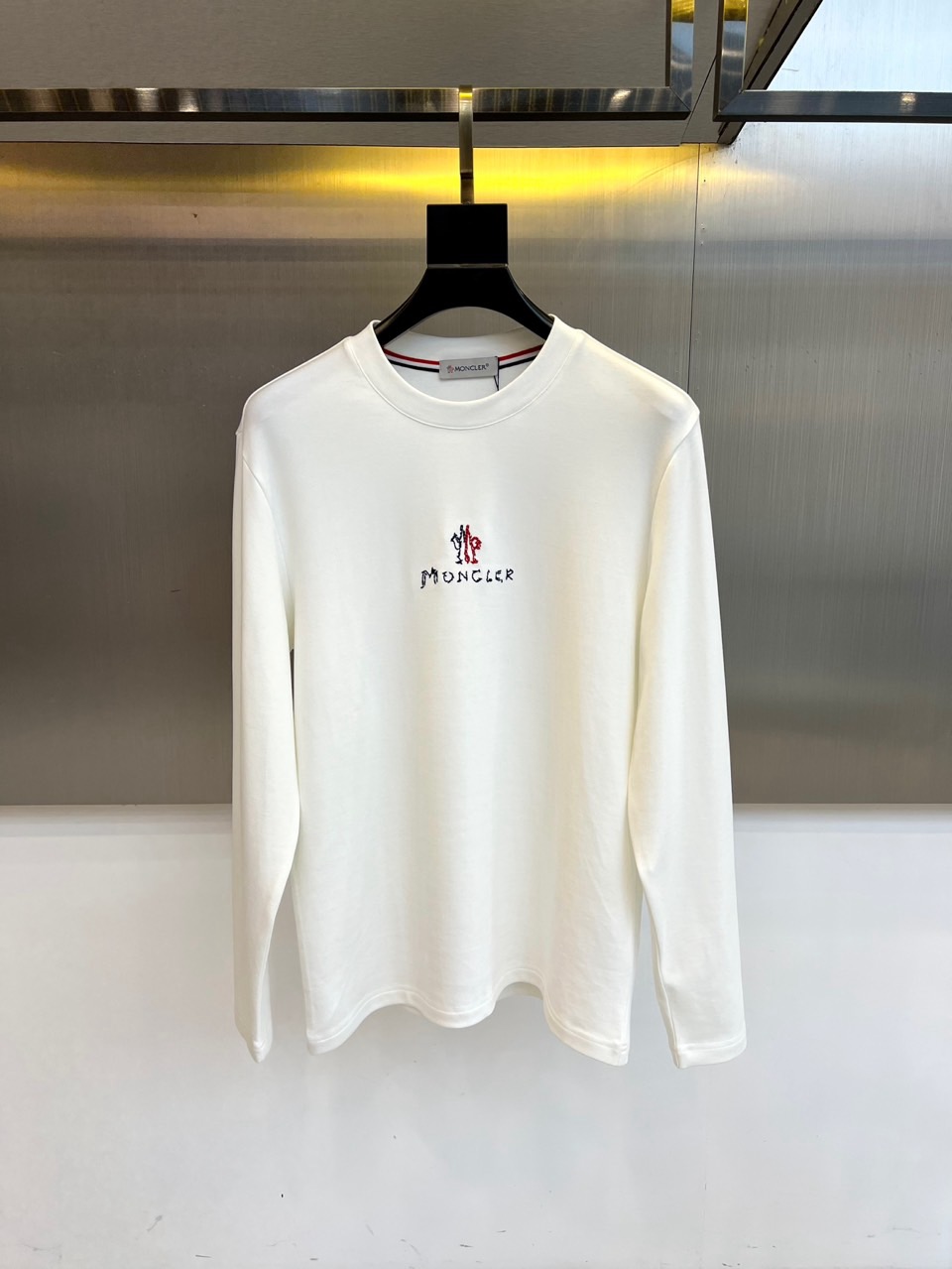 NO:598624,Mon, the 2025 autumn and winter new long-sleeved T-shirt, interprets urban casual aesthetics with a minimalist round neck design. The style adopts a classic silhouette, with the brand's iconic embroidered logo on the chest, and a double row of 'MONCLER' letters presented with exquisite stitching, highlighting a low-key luxury. The fabric is made of high-quality cotton to ensure a soft and skin-friendly wearing experience, with both breathability and warmth. Its design combines sports genes with daily practicality, and can be paired with jeans alone  Pants create a simple look, and can also be layered with a down jacket to adapt to changing weather. From city walks to weekend trips, this T-shirt has become a must-have item that connects high-end craftsmanship and lifestyle with its ingenious craftsmanship and versatile features of embroidered details, interpreting Moncler's pursuit of both comfort and style. 48-56 (model is 173,143 pounds, upper body size 50),,Moncler,jeans,jackets  & coats,tees,t-shirt,down jacket,alexander wang19860909Mon蒙口、2025秋冬新品长袖T恤,以极简圆领设计诠释都市休闲美学.款式采用经典廓形,胸前点缀品牌标志性刺绣徽标,双排'MONCLER'字母以精致针脚呈现,彰显低调奢华感.面料选用高品质棉质材质,确保柔软亲肤的穿着体验,兼具透气性与保暖性.其设计将运动基因与日常实穿性相融合,可单独搭配牛仔裤打造简约造型,亦可作为内搭与羽绒外套层叠穿搭适应多变天气.从城市漫步到周末出行,这款T恤以刺绣细节的匠心工艺与百搭特性,成为连接高端工艺与生活方式的必备单品,诠释Moncler对舒适与风格并重的追求.48-56（模特173,143斤上身50码）,,Moncler,jeans,jackets & coats,tees，t-shirt,down jacket,alexander wang,Men's clothing