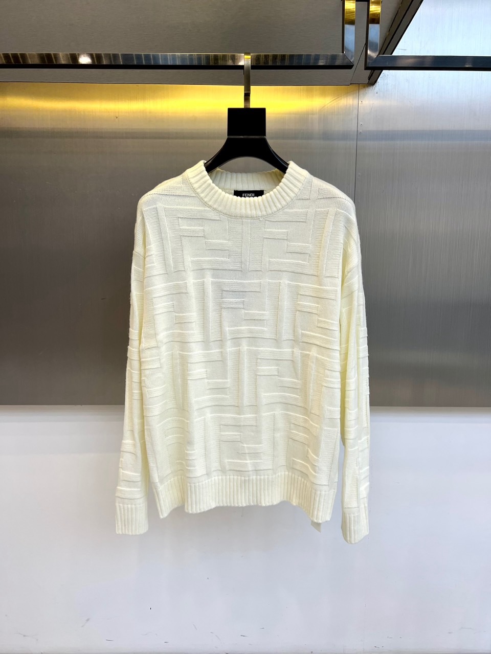 NO:598609,FEND Fendi, the new white knitted sweater for autumn and winter 2025, interprets Italian elegant aesthetics with geometric relief texture. The round neck design adopts ribbing edge technology, and the body is formed by three-dimensional cable weaving to form a patchwork diamond pattern, which creates a three-dimensional texture like architectural lines. The fabric is made of high-quality cotton blend material to ensure a soft and skin-friendly wearing experience. Its design combines classic knitting technology with modern geometric aesthetics, and can be paired with a skirt to show sophistication  The temperament can also be combined with casual trousers to create a fun mix and match. From daily commuting to weekend socializing, this sweater has a simple but not simple design language, becoming a fashion carrier that connects Italian ingenuity and contemporary life, interpreting FENDI's precise control of details and silhouette. 48-56 (model 173,143 pounds, upper body 50?),, fendi, fendi, skirts, sweaters, alexander  wang19860909FEND芬迪、2025秋冬新品白色针织毛衣,以几何浮雕纹理演绎意式优雅美学.圆领设计采用罗纹收边工艺,衣身通过立体绞花编织形成错落有致的菱形图案,宛如建筑线条般构筑出三维质感.面料选用高品质棉混纺材质,确保柔软亲肤的穿着体验.其设计将经典针织工艺与现代几何美学相融合,可搭配半身裙展现精致气质,亦可与休闲裤装碰撞出混搭趣味.从日常通勤到周末社交,这款毛衣以简约而不简单的设计语言,成为连接意式匠心与当代生活的时尚载体,诠释FENDI对细节与廓形的精准把控.48-56（模特173,143斤上身50吗）,,fendi,fendi,skirts,sweaters,alexander wang,Men's clothing