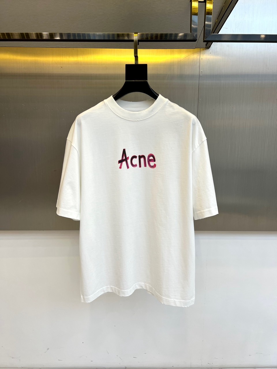 NO:598619,Acne Studios-2025 autumn and winter new pure cotton T-shirt interprets Nordic modern aesthetics with minimalist design. The style adopts a classic round neck and short-sleeved silhouette, and the body is made of combed cotton. The fabric is sanded to present a delicate texture. The brand's iconic red 'Acne' logo is embellished on the chest, and the font uses old technology to create a retro texture, forming a distinct visual collision with the pure white base.  Its design integrates Scandinavian minimalist genes into daily wear, with a loose fit that combines comfort and style. It can be paired with jeans alone to show a casual style, or it can be layered with a suit jacket. From urban life to art exhibitions, this T-shirt combines the retro charm of the old logo with pure cotton  The skin-friendly experience of the fabric has become a carrier that connects simple aesthetics and practicality, interpreting the brand's pioneering interpretation of daily wear. The washing label recommends gentle machine washing at 30 degrees and drying on the reverse side to maintain the color of the logo. S-XL (model 173, 143 pounds, upper body size M),,acne  studios,dior,jeans,jackets & coats,T-shirt,tees,t-shirt,business suit,alexander wang19860909Acne Studios-2025秋冬新品纯棉T恤,以极简设计诠释北欧现代美学.款式采用经典圆领短袖廓形,衣身选用精梳棉材质,面料通过磨毛处理呈现细腻肌理感.胸前点缀品牌标志性红色'Acne'标识,字体采用做旧工艺打造复古质感,与纯净白色基底形成鲜明视觉碰撞. 其设计将斯堪的纳维亚极简基因融入日常着装,宽松版型兼顾舒适度与造型感.可单独搭配牛仔裤展现休闲风格,亦可作为内搭与西装外套层叠穿搭.从都市生活到艺术展览,这款T恤以做旧标识的复古韵味与纯棉面料的亲肤体验,成为连接简约美学与实穿主义的载体,诠释品牌对日常着装的先锋解读.洗涤标签建议30度水温轻柔机洗,反面晾晒以保持标识色泽.S-XL（模特173,143斤上身M码）,,acne studios,dior,jeans,jackets & coats,T-shirt,tees，t-shirt,business suit,alexander wang,Men's clothing