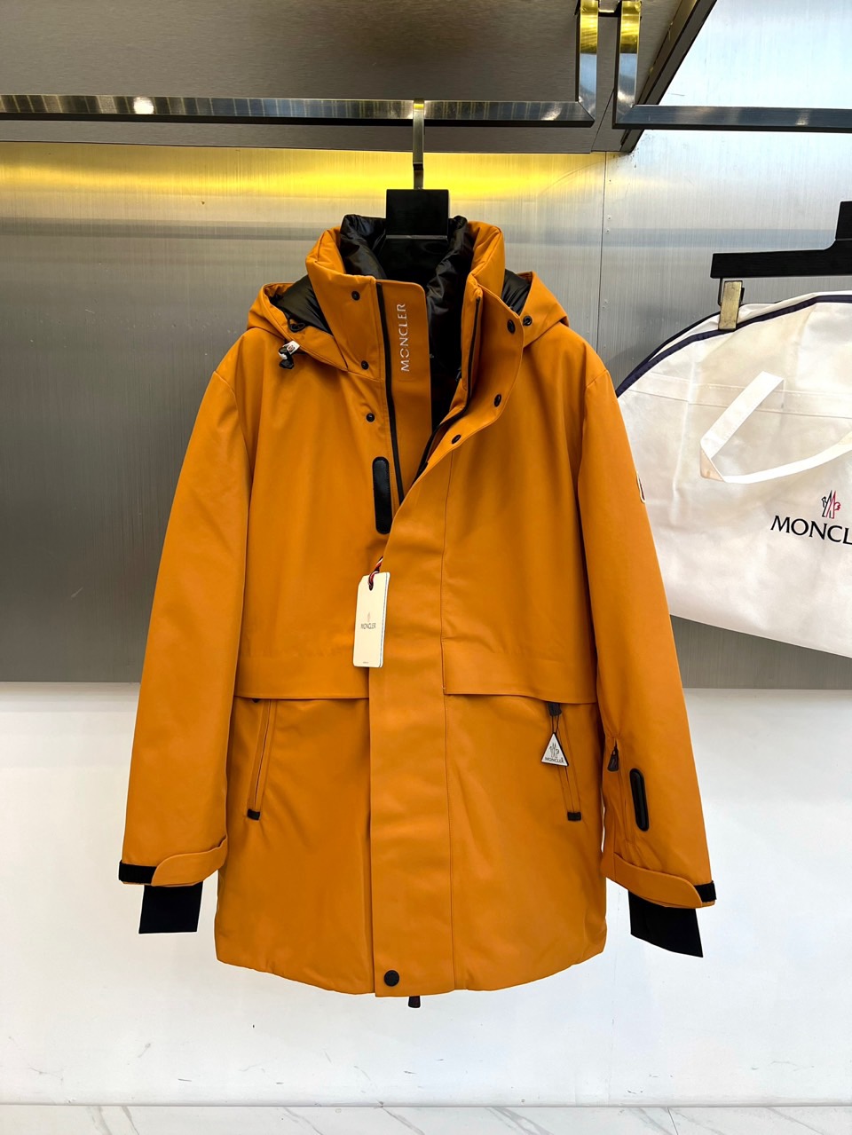 NO:598623,Moncler's hooded (goose down), 2025 autumn and winter new mid-length ski suit, uses a warm and mellow warm brown color to interpret the Alpine aesthetics. The style adopts a hooded design, and the hood is lined with black fabric to create a visual contrast. The front uses a black button and zipper double closure system to enhance windproof and warm performance. The body is equipped with two practical chest pockets with zippers, and the cuffs are embellished with black decorative strips to echo the overall design. The left side is decorated with the brand's classic logo, highlighting the luxury outdoor gene.  The fabric and lining are made of nylon to ensure windproof and wear-resistant performance; the filling is 90% high-quality white goose down, which strictly follows international down standards. Its three-dimensional tailoring takes into account the needs of ski sports and daily wearability. It can be paired with professional snow pants to complete the equipment system, and can also be integrated into urban winter wear. From skiing to the city  Shuttle, this ski suit uses fine craftsmanship and professional protective configuration made in Romania, becoming a model that connects mountain adventure and fashionable life, interpreting Moncler's ultimate pursuit of functional aesthetics. Sizes 1-5 (model 173,143 pounds upper body size 2),,Moncler,down  jacket,hats,alexander wang19860909Moncler蒙口（鹅绒）、 2025秋冬新品中长款滑雪服,以温暖醇厚的暖棕色演绎阿尔卑斯山系美学.款式采用连帽设计,帽内衬采用黑色面料形成视觉对比,前襟创新性地采用黑色纽扣与拉链双重闭合系统,增强防风保暖性能.衣身配备两个带拉链的实用胸袋,袖口点缀黑色装饰条与整体设计呼应.左侧饰有品牌经典徽标,彰显奢华户外基因. 面料与里料均采用锦纶材质,确保防风耐磨性能；填充物为90高品质白鹅绒,严格遵循国际羽绒标准.其立体剪裁兼顾滑雪运动需求与日常实穿性,可搭配专业雪裤完善装备体系,亦能融入都市冬日穿搭.从雪场驰骋到城市穿梭,这款滑雪服以罗马尼亚制造的精细工艺与专业防护配置,成为连接高山探险与时尚生活的典范之作,诠释Moncler对机能美学的极致追求.1-5码（模特173,143斤上身2码）,,Moncler,down jacket,hats,alexander wang,Men's clothing