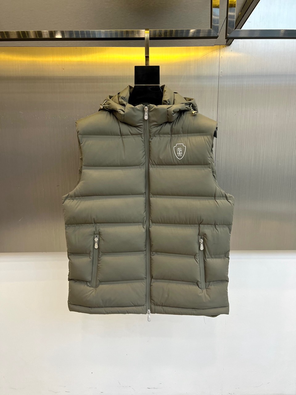 NO:599930,Brunello  Cucinelli-2025 new autumn and winter down vest, a calm interpretation of the outdoor aesthetics of modern urban elites. The item is made of nylon fabric to create a windproof shell, filled with 90% high-quality white duck down, which is lightweight, warm, environmentally friendly and traceable. The hood design and front zipper meet multi-functional wearing needs, and the zipper pockets on both sides are both practical and smooth. The iconic embroidered logo on the left chest is low-key embellishment with the same color thread process, showing  It is Italian-style and subtle luxury. The slim tailoring optimizes the proportions of the body. It can be worn under a sweater to create a sense of layering, or worn over a windbreaker to cope with temperature changes. By integrating high-end outdoor functions with exquisite Italian tailoring, this vest has become a fashionable item that connects business and leisure scenes, perfectly interpreting the brand philosophy of 'low-key luxury'. 48-56 (model is 173, 143 pounds, upper body size 50), brunello  cucinelli,down jacket,hats,alexander wang19860909Brunello Cucinelli-2025秋冬新品羽绒马甲,以沉稳诠释现代都市精英的户外美学.单品采用锦纶面料打造防风外壳,内填充90优质白鸭绒,轻盈保暖且环保可追溯.连帽设计与前襟拉链满足多功能穿着需求,两侧拉链口袋兼顾实用性与流畅轮廓.左胸标志性刺绣徽标以同色线工艺低调点缀,展现意式含蓄奢华.修身剪裁优化身材比例,可内搭针织衫塑造层次感,或外穿于风衣外应对温差变化.通过将高端户外机能与意大利精致剪裁相融合,这件马甲成为连接商务与休闲场景的时尚单品,完美诠释'低调的奢华'品牌哲学.48-56（模特173,143斤上身50码）,,brunello cucinelli,down jacket,hats,alexander wang,Men's clothing