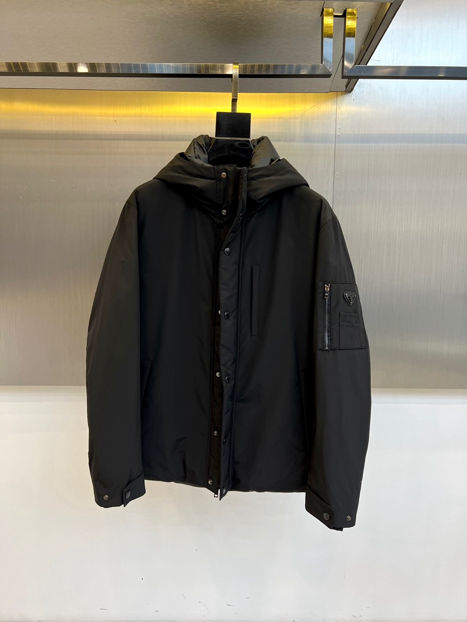 NO:599933,Prada (Goose Down) 2025 Autumn and Winter New Black Hooded Down Jacket, which reshapes the urban sports style with simple and neat tailoring. It adopts a zipper opening design with a low-key zipper of the same color. The left chest is embellished with the brand's classic logo embroidery, and the cuffs are decorated with black leather 'DIOR'  The label highlights the luxurious genes in every detail. The jacket is made of crisp windproof fabric, taking into account both practicality and fashion. The black down jacket of the same series continues the ultimate craftsmanship. The outer layer is made of 60 polyester fiber, 25 merino wool and 15 viscose fiber blended knitted fabric, and the inner lining is polyester fiber.  Filled with 90% white goose down, it ensures excellent warmth while maintaining a light feel. Both items are presented in deep black, perfectly interpreting Dior's low-key and luxurious aesthetic language. Whether it is the urban functional style of the hooded jacket or the ultimate warmth of the down jacket, it can be easily matched with all types of autumn.  Winter clothing meets a variety of needs from daily commuting to outdoor activities, showing the exquisite taste and pragmatic fashion attitude of modern urbanites. 48-56 (model weighs 173,143 pounds, upper body size 50),, dior, dior, prada, jackets  & coats,jackets & coats,down jacket,hats,alexander wang19860909普拉达（鹅绒）2025秋冬新品黑色连帽羽绒服夹克外套,以简约利落的剪裁重塑都市运动风范.采用拉链开合设计,搭配同色系低调拉链,左胸点缀品牌经典标志刺绣,袖口饰以黑色皮质'DIOR'标签,于细节处彰显奢华基因.外套选用挺括防风面料,兼顾实用性与时尚度.同系列黑色羽绒服延续极致工艺,外层采用60聚酯纤维、25美利奴羊毛与15粘胶纤维混纺针织面料,内衬为聚酯纤维,填充90白色鹅绒,确保卓越保暖性的同时保持轻盈体感.两件单品均以深邃黑色呈现,完美诠释迪奥低调奢华的美学语言.无论是连帽夹克的都市机能风格,还是羽绒服的极致保暖性能,皆能轻松搭配各类秋冬着装,满足从日常通勤到户外活动的多种需求,展现摩登都市人的精致品味与实用主义时尚态度.48-56（模特173,143斤上身50码）,,dior,dior,prada,jackets & coats,jackets & coats,down jacket,hats,alexander wang,Men's clothing