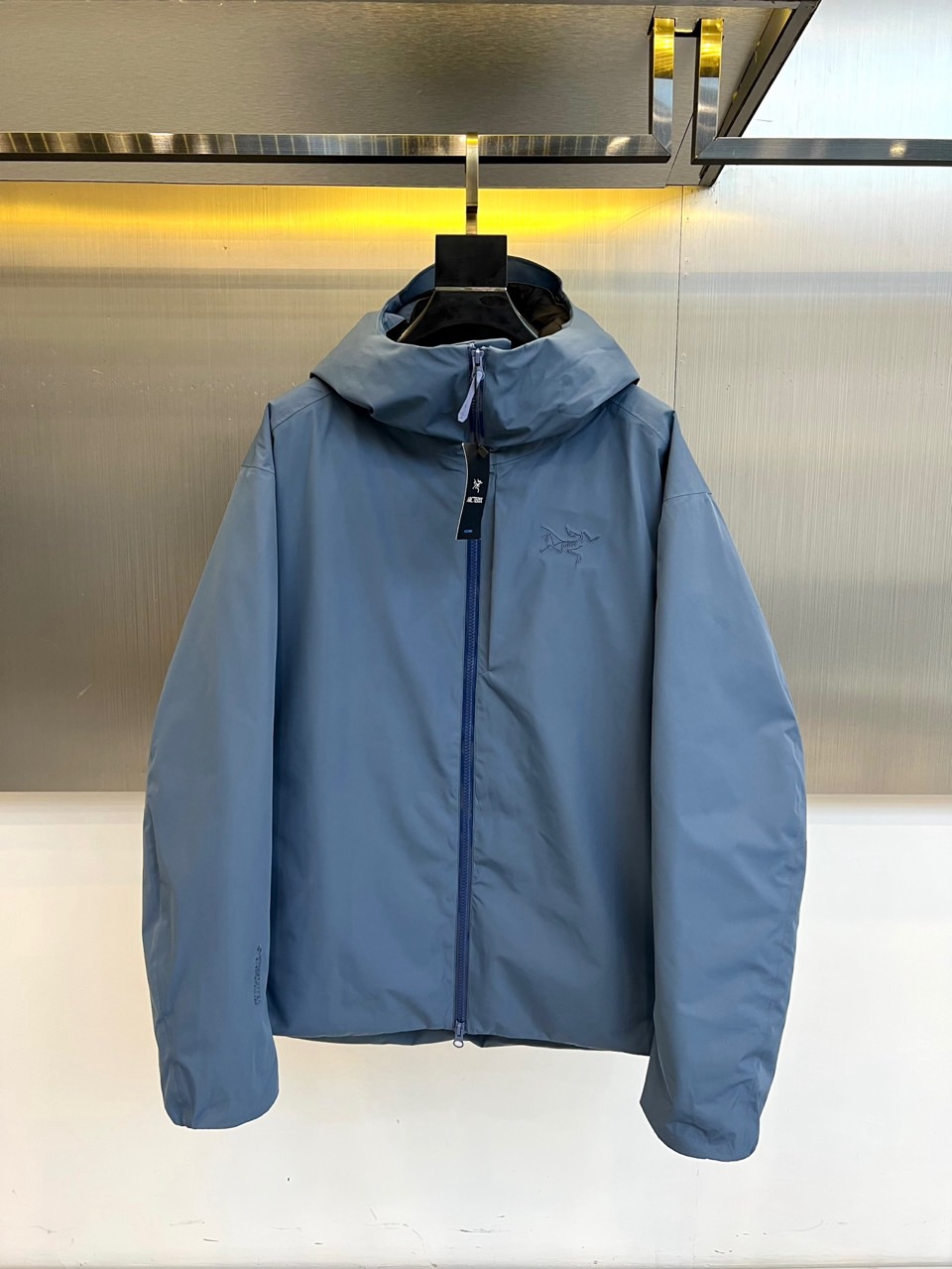 NO:599936,Arcteryx (goose down), the new 2025 autumn and winter hooded down jacket, uses a fresh and elegant light blue tone to interpret the perfect integration of outdoor functions and urban aesthetics. This jacket uses an exquisite fabric ratio of 66 cotton, 20 nylon and 14 spandex, which ensures  The skin-friendly breathability of cotton is retained, and the wear-resistant strength is enhanced by nylon, while the spandex component gives the clothing just the right elasticity and flexibility. The hooded design and dark blue zipper form a distinct visual hierarchy, and the brand's classic embroidered logo is embellished on the left chest, highlighting its professional outdoor pedigree. The inner layer is made of  Double-layer structure design, lining 1 continues the main fabric ratio to ensure a comfortable feel, lining 2 is made of polyester fiber to enhance windproof and warm performance. Three-dimensional tailoring takes into account freedom of movement and neat silhouette, and the subtle logo on the cuffs reflects the dedication to details. From exploring the mountains to walking in the city, this piece  Based on Arc'teryx's iconic craftsmanship standards, the jacket integrates professional protective performance into the context of daily dressing, becoming an all-round fashion equipment that connects nature and the city. 48-56 (model weighs 173,143 pounds, upper body size 50), arc'teryx, jackets  & coats,down jacket,hats,alexander wang19860909Arcteryx始祖鸟（鹅绒）、2025秋冬新品连帽羽绒服外套,以清新雅致的浅蓝色调演绎户外功能与都市美学的完美融合.这款外套采用66棉、20锦纶与14氨纶的精妙面料配比,既保留了棉质的亲肤透气性,又通过锦纶增强耐磨强度,氨纶成分则赋予衣物恰到好处的弹性灵活度.连帽设计与深蓝色拉链形成鲜明视觉层次,左胸处点缀品牌经典刺绣徽标,彰显专业户外血统.内层采用双层结构设计,里料1延续主体面料配比确保舒适体感,里料2采用聚酯纤维增强防风保暖性能.立体剪裁兼顾运动自由度与利落轮廓,袖口细微标识体现对细节的执着.从山野探索到都市穿行,这件外套以始祖鸟标志性的工艺标准,将专业防护性能融入日常着装语境,成为连接自然与城市的全能型时尚装备.48-56（模特173,143斤上身50码）,arc'teryx,jackets & coats,down jacket,hats,alexander wang,Men's clothing