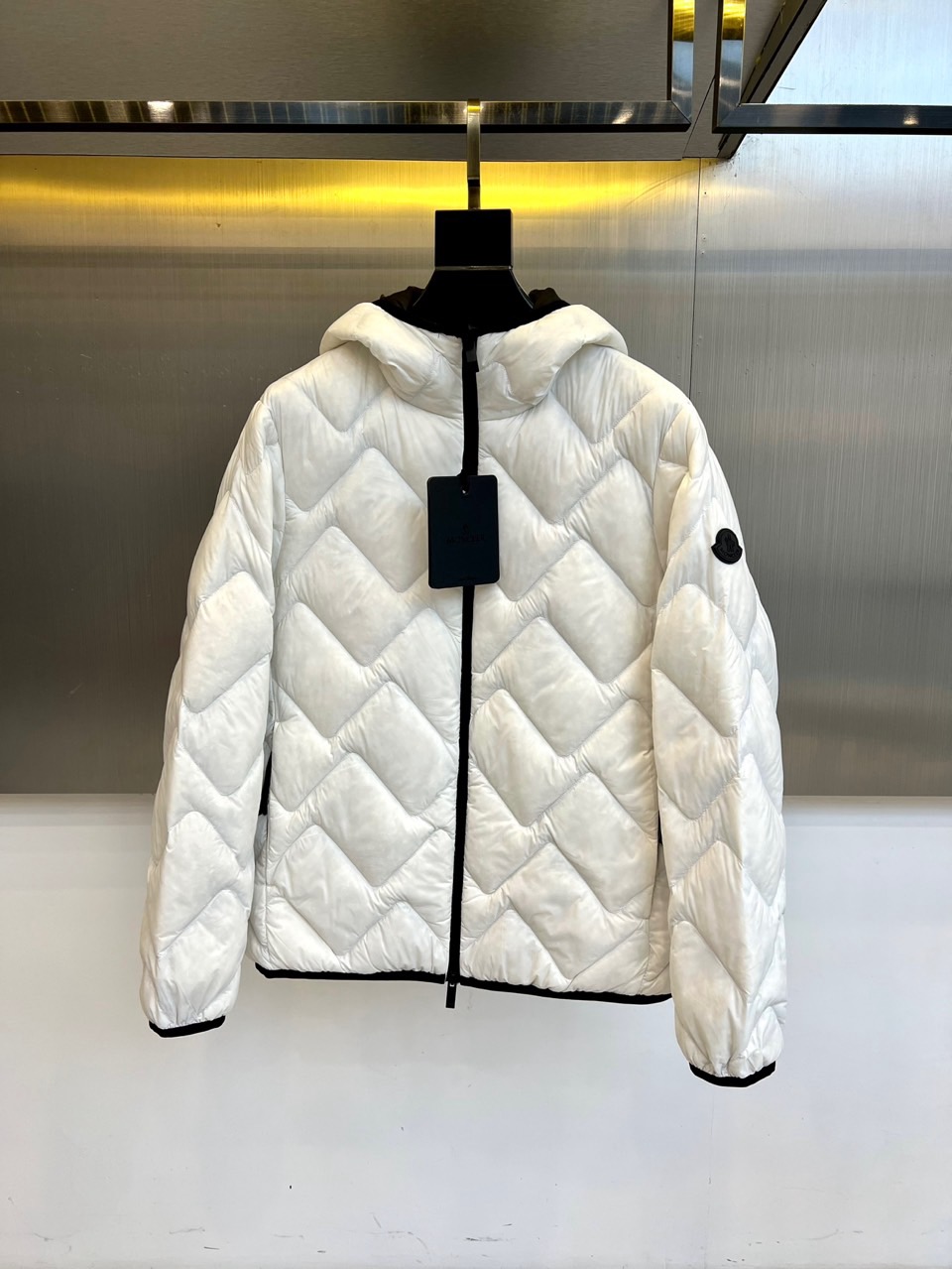 NO:599939,Mon, the new down jacket for autumn and winter 2025, this down jacket uses classic diamond plaid quilting technology to effectively fix high-quality down filling, ensuring excellent warmth while shaping a three-dimensional silhouette. The hooded design enhances windproof practicality, and is paired with a smooth black front zipper to create a sharp visual contrast. The left sleeve is embellished with the brand's iconic logo, highlighting its identity with simple details. Fabric selection  Made of lightweight materials, it combines thermal performance and wearing comfort. The overall design perfectly combines practical functions with fashionable temperament. It can be paired with casual trousers to create a daily look, or it can be combined with high-end accessories to create a modern spark. It has become an ideal choice for both warmth and style in autumn and winter. 48-56 (model 173, 143 pounds, upper body size 50), Moncler, down  jacket,hats,alexander wang19860909Mon蒙口、2025秋冬新品羽绒服,这款羽绒服采用经典菱形格纹绗缝工艺,有效固定高品质羽绒填充,确保卓越保暖性的同时塑造立体轮廓.连帽设计增强防风实用性,搭配顺滑的黑色前襟拉链形成鲜明视觉对比.左袖点缀品牌标志性徽标,以简约细节彰显身份.面料选用轻盈材质,兼顾保暖性能与穿着舒适度.整体设计将实用功能与时尚气质完美融合,既可搭配休闲裤装打造日常造型,也能与高端配饰碰撞出摩登火花,成为秋冬季节兼具温度与风度的理想选择.48-56（模特173,143斤上身50码）,,Moncler,down jacket,hats,alexander wang,Men's clothing