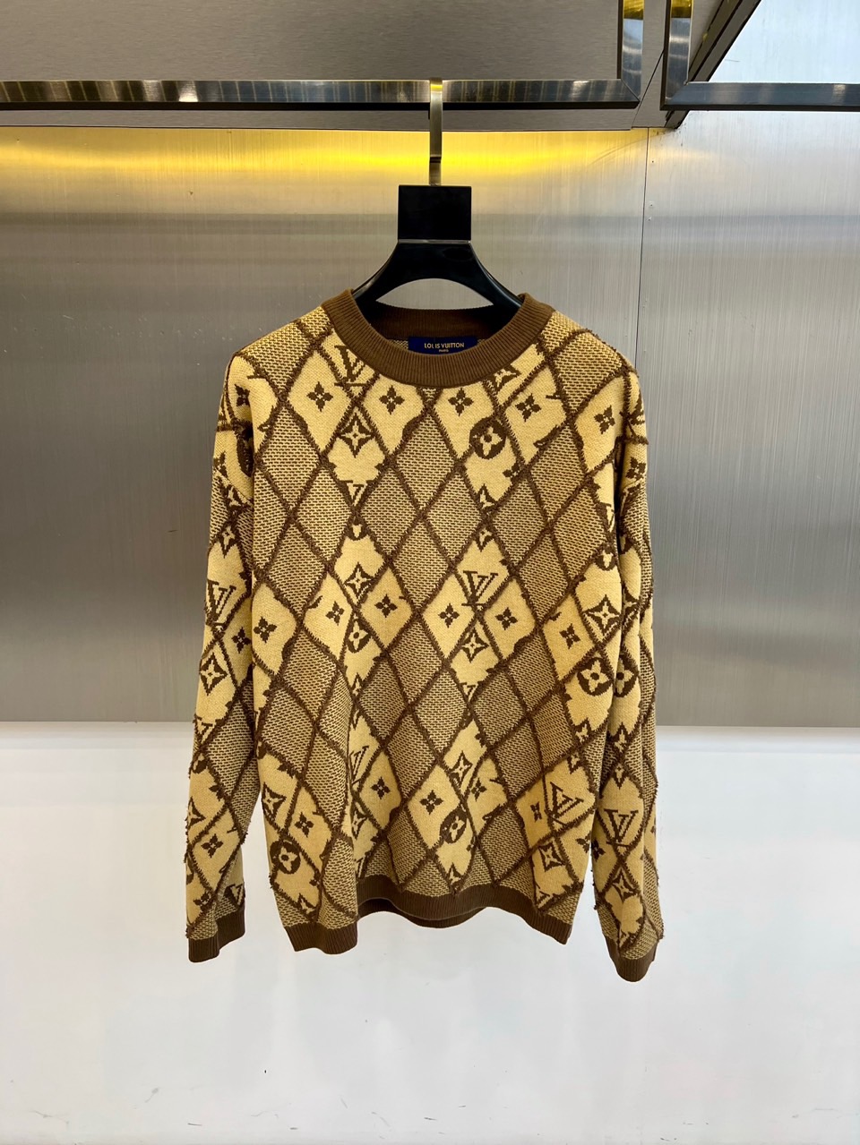 NO:599943,1v Vuitton, the new 2025 autumn and winter gray rhombus knitted sweater, reshapes the classic knitted aesthetics with the brand's iconic Monogram presbyopia pattern. The style adopts a slim round neck design, the body is covered with three-dimensional rhombus patterns, intertwined with the faint LV letter print, and the cuffs and hem are ribbed to ensure a crisp fit. The fabric is made of worsted cotton, and the gray and white color combination not only retains the brand's genes but also adds a modern feel.  Its design combines traditional knitting techniques with street elements. The diamond pattern enhances the visual layering. It can be paired with a leather skirt to show a modern temperament, or it can be paired with straight jeans for a casual fashion. From the opening of an art exhibition to a city stroll, this sweater has a low-key presbyopic pattern and a clever combination of diamond texture. It has become a fashion carrier that connects century-old heritage and contemporary life, interpreting Louis  Vuitton's innovative interpretation of classic items. 48-56 (model is 173,143 pounds and 50 upper body,,louis vuitton,louis vuitton,skirts,jeans,alexander wang198609091v威登、2025秋冬新品灰色菱格纹针织衫,以品牌标志性Monogram老花图案重塑经典针织美学.款式采用修身圆领设计,衣身满铺立体菱格纹路,交织着若隐若现的LV字母印花,袖口与下摆采用罗纹收边工艺确保版型挺括.面料选用精纺棉质材质,灰白配色既保留品牌基因又增添现代感. 其设计将传统针织工艺与街头元素相融合,菱格纹路增强视觉层次感,可搭配皮革半裙展现摩登气质,亦可与直筒牛仔裤碰撞出休闲时尚.从艺术展开幕到都市漫步,这款针织衫以低调的老花图案与菱格纹理的巧妙结合,成为连接百年传承与当代生活的时尚载体,诠释Louis Vuitton对经典单品的创新演绎.48-56（模特173,143斤上身50吗,,louis vuitton,louis vuitton,skirts,jeans,alexander wang,Men's clothing