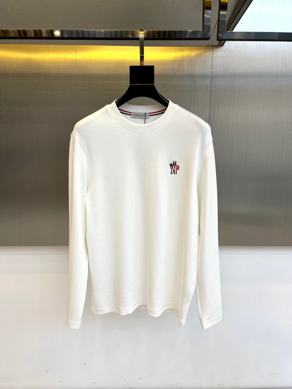 NO:599952,Mon Mengkou,  The new 2025 autumn and winter long-sleeved T-shirt interprets urban sports aesthetics with minimalist design. The style adopts a classic round neck design, with the brand's iconic red, blue and white rib stripes integrated into the neckline, and the left chest is embellished with exquisite embroidered brand logo. The fabric is made of high-quality cotton to ensure skin-friendly breathability. Its tailoring pays attention to the three-dimensional silhouette and freedom of movement. It can be worn alone with casual pants to create a simple look, or it can be worn alone  As an inner wear layered with a down jacket. From daily outings to outdoor activities, this T-shirt has iconic color details and exquisite embroidery technology, becoming a must-have item that connects sports genes and fashion attitude, interpreting Moncler's persistent pursuit of practical aesthetics. 48-56 (model is 173, 143 pounds, upper body size 50),, Moncler, jackets  & coats,tees,t-shirt,down jacket,alexander wang19860909Mon蒙口、 2025秋冬新品长袖T恤,以极简设计诠释都市运动美学.款式采用经典圆领设计,领口融入品牌标志性红蓝白三色罗纹条纹,左胸点缀精致刺绣品牌标识.面料选用高品质棉质材质,确保亲肤透气性.其剪裁注重立体轮廓与活动自由度,可单穿搭配休闲裤打造简约造型,亦可作为内搭与羽绒外套层叠穿搭.从日常出街到户外活动,这款T恤以标志性色彩细节与精湛刺绣工艺,成为连接运动基因与时尚态度的必备单品,诠释Moncler对实用美学的执着追求.48-56（模特173,143斤上身50码）,,Moncler,jackets & coats,tees，t-shirt,down jacket,alexander wang,Men's clothing