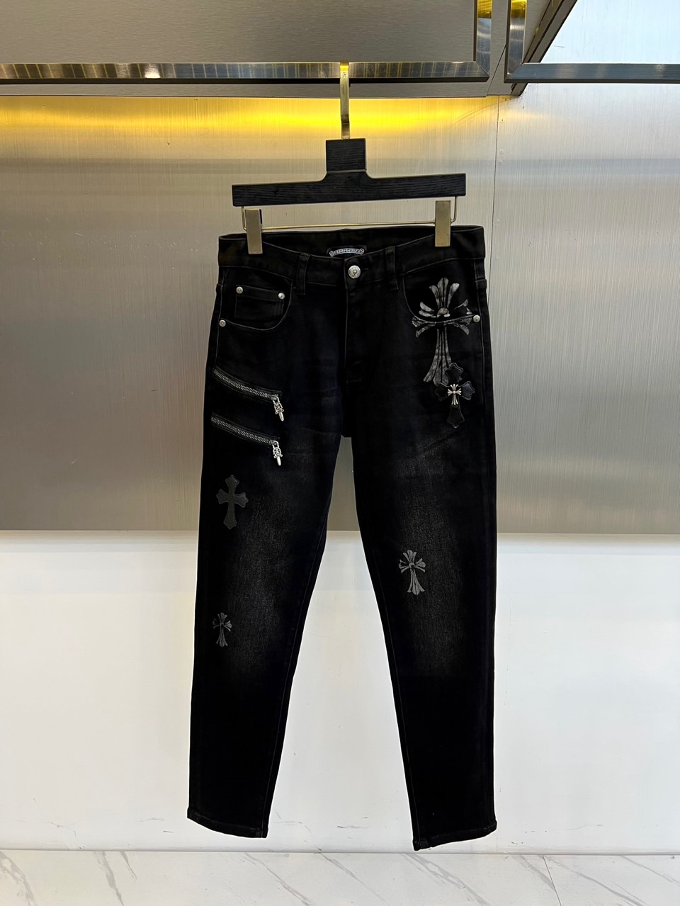 NO:599926,Chrome Hearts  The new black jeans for autumn and winter 2025 reshape street fashion with Gothic aesthetics. The style adopts a straight cut with a high-waist design. The pants are covered with the brand's iconic cross embroidery pattern. The crosses of different sizes present delicate textures through three-dimensional stitching. Customized metal on the right thigh  The zipper becomes the focus, and the jagged zipper pull is inlaid with the brand's letter logo, forming a dark symphony with the cross element. The fabric is made of cotton, which is breathable and moisture-absorbing through special treatment. The lining label indicates the special process number of 'Bed No. 31', symbolizing its antibacterial and anti-odor technological properties.  Its design continues the brand's delicate feel like handmade silverware, with the arrangement of the crosses echoing the rhythm of the human body curves. It can be paired with a simple leather top to enhance the overall dark style, or it can be used to create a layered aesthetic through a deconstructed tailoring jacket. From night parties to art exhibitions, these jeans use the religious metaphor of the cross element, the industrial texture of the metal zipper and the practical performance of cotton fabric to become a carrier that connects Gothic culture and contemporary clothing, interpreting Chrome Hearts' dual exploration of eternity and subversion. 29-36 (available in size 35), chrome  hearts,jeans,jackets & coats,alexander wang19860909Chrome Hearts 2025秋冬新品黑色牛仔裤,以哥特美学重塑街头时尚.款式采用直筒剪裁搭配高腰设计,裤身满铺品牌标志性的十字架刺绣图案,大小不一的十字架通过立体针法呈现细腻纹理.右侧大腿处的定制金属拉链成为焦点,锯齿状拉链头镶嵌品牌字母标识,与十字架元素形成暗黑交响.面料选用棉质材质,通过特殊处理实现透气吸湿功能,内衬标签注明'31号床'特殊工艺编号,象征其抗菌防味的科技属性. 其设计延续品牌手工银器般的精致感,十字架排列暗合人体曲线韵律.可搭配简约皮革上衣强化整体暗黑风格,亦能通过解构式剪裁外套碰撞出层次美学.从夜间派对到艺术展览,这款牛仔裤以十字架元素的宗教隐喻、金属拉链的工业质感及棉质面料的实用性能,成为连接哥特文化与当代着装的载体,诠释Chrome Hearts对永恒性与颠覆性的双重探索.29-36（有35码）,,chrome hearts,jeans,jackets & coats,alexander wang,Men's clothing