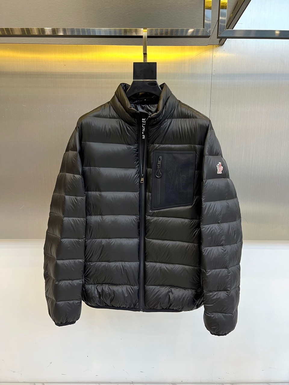 NO:599941,Mon, the 2025 autumn and winter new black down jacket, interprets urban functional aesthetics with a neat stand-up collar design. The style adopts a smooth zipper opening and closing system, and is equipped with a practical pocket with a zipper on the front chest. The left sleeve is embellished with the brand's iconic badge to show your identity. The body is through  The precise horizontal quilting process forms a three-dimensional modular structure to ensure even distribution of fillings. The fabric and lining are made of nylon, filled with high-quality duck down with 90% down content, and strictly comply with GB/T14272-down standards and Class C safety regulations.  Its design combines Alpine outdoor genes with modern tailoring. The stand-up collar design enhances wind resistance, and horizontal quilting optimizes thermal insulation efficiency. It can be paired with casual trousers to create an urban look, or it can also cope with light outdoor scenes. From urban commuting to outings in the suburbs, this down jacket has a neat look.  Geometric lines and professional down craftsmanship have become a winter model that connects mountain protection and daily fashion, interpreting Moncler's in-depth exploration of functional aesthetics. 48-56 (model weighs 173,143 pounds, upper body size 50),,Moncler,down  jacket,alexander wang19860909Mon蒙口、2025秋冬新品黑色羽绒服,以利落立领设计诠释都市机能美学.款式采用顺滑拉链开合系统,前胸配备带拉链的实用口袋,左袖点缀品牌标志性徽章彰显身份.衣身通过精准的横向绗缝工艺形成立体模块化结构,确保填充物均匀分布.面料与里料均采用锦纶材质,填充90绒子含量的优质鸭绒,严格执行GB/T14272-羽绒标准与C类安全规范. 其设计将阿尔卑斯户外基因与现代剪裁相融合,立领设计增强防风性,横向绗缝优化保暖效率.可搭配休闲长裤打造都市造型,亦可应对轻度户外场景.从城市通勤到郊外出行,这款羽绒服以规整的几何线条与专业羽绒工艺,成为连接高山防护与日常时尚的冬季典范,诠释Moncler对功能美学的深度探索.48-56（模特173,143斤上身50码）,,Moncler,down jacket,alexander wang,Men's clothing