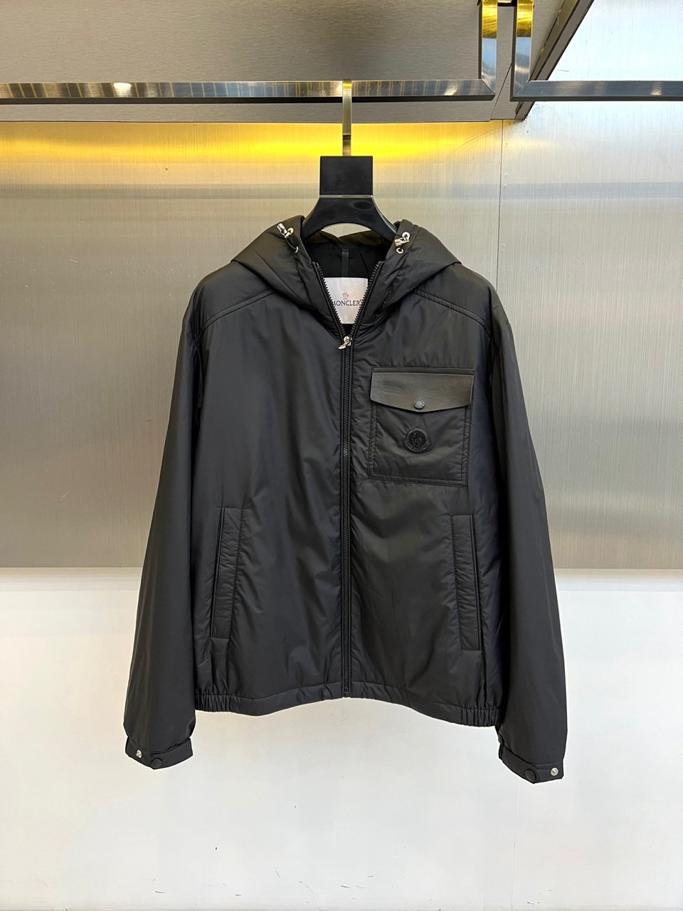 NO:600846,Mon, new products for autumn and winter 2025  Men's hooded cotton jacket. This black jacket has a stand-up collar and hood design. The brim and front placket are equipped with silver metal adjustment fasteners. The left chest is decorated with the brand's iconic logo embroidery. The diagonal pockets on both sides are designed with waterproof zippers, and the cuffs adopt a snap-button adjustment system to ensure windproof effect. The main fabric is made of polyester fiber, and the lining and filling are also made of polyester fiber, which is lightweight through special processing.  Quantitative thermal effect. The built-in drawstring at the hem can be freely adjusted for tightness. Details reflect outdoor functional aesthetics, including reflective element processing and multi-functional storage pocket design. It is suitable for urban commuting and outdoor activities and other scenes, showing a modern outdoor style that combines practical functions and fashion. 48-56 (model is 173, 143 pounds, upper body size 50), Moncler, jackets  & coats,jackets & coats,hats,alexander wang19860909Mon蒙口、2025秋冬新品 男士连帽棉服夹克外套.这款黑色夹克采用立领连帽设计,帽檐与前襟配备银色金属调节扣件,左胸位置饰有品牌标志性徽标刺绣.两侧斜插口袋融入防水拉链设计,袖口采用按扣调节系统确保防风效果.主体面料采用聚酯纤维材质,里料与填充物同样选用聚酯纤维,通过特殊工艺处理实现轻量化保暖效果.下摆内置抽绳可自由调节松紧.细节处体现户外机能美学,包括反光元素处理与多功能储物口袋设计.适合都市通勤与户外活动等多场景穿着,展现兼具实用功能与时尚感的现代户外风格.48-56（模特173,143斤上身50码）,,Moncler,jackets & coats,jackets & coats,hats,alexander wang,Men's clothing