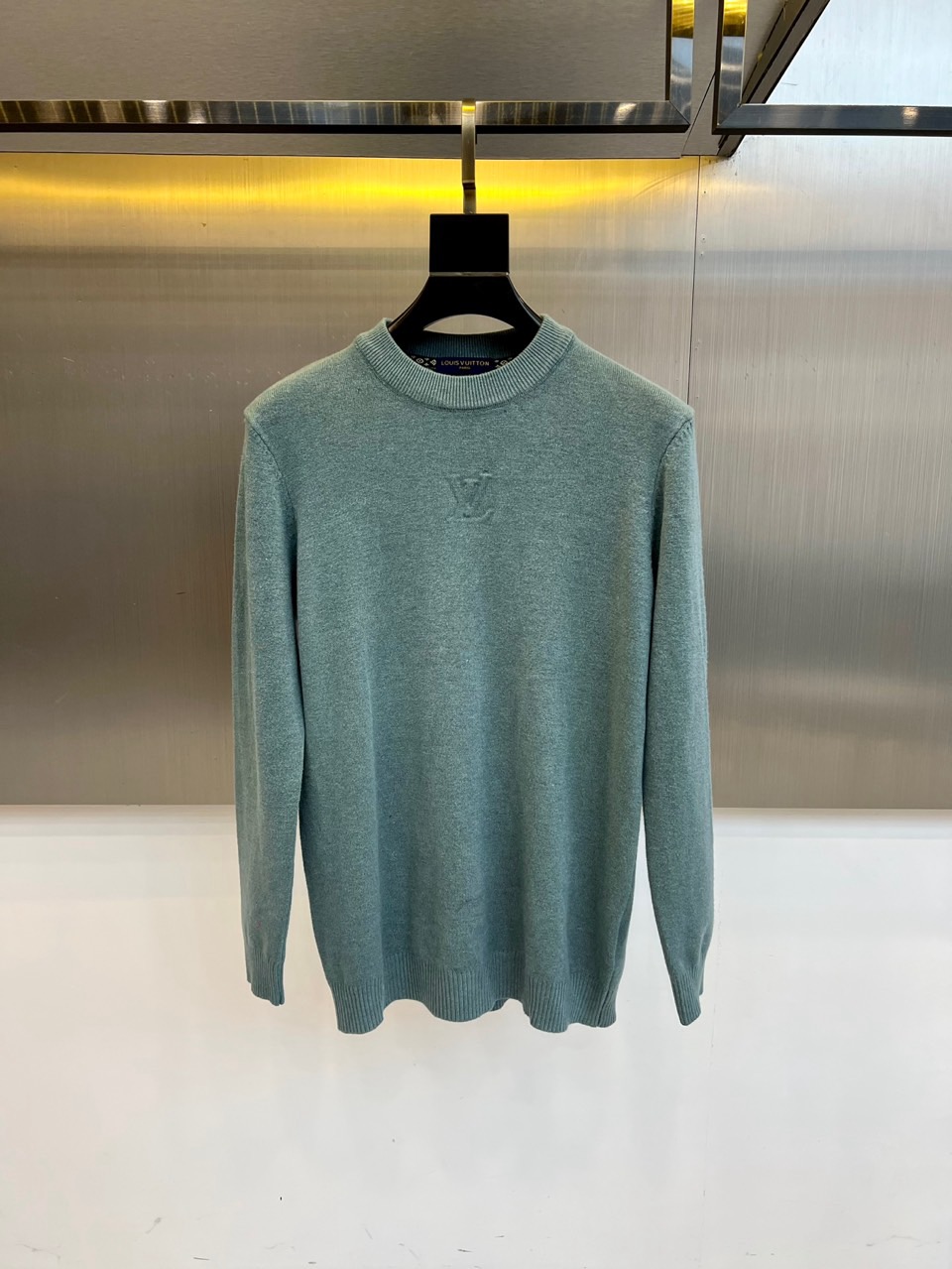 NO:600850,1v Vuitton, 2025 autumn and winter new season sweater, the round neck design adopts three-dimensional tailoring technology, and the curvature of the collar accurately fits the neck line. The body is made of virgin wool, and Italian hand-spinning technology creates a fine and uniform knitted texture. The front is decorated with the classic LV monogram embossed logo, and the brand's unique embossing technology is used to present a three-dimensional texture.  This product continues Louis Vuitton's pursuit of high standards for materials. The wool raw material has undergone special anti-shrinkage treatment to ensure a stable pattern. The label indicates that professional maintenance guidelines require gentle dry cleaning procedures, and a cloth is required when ironing at low temperatures to avoid direct contact with the iron soleplate. The label of Italian origin highlights the brand's century-old production process.  It can be paired with leather items of the same brand to enhance the overall look, or it can be combined with casual bottoms for a fun mix and match. From business meetings to weekend socializing, this sweater, with its low-key embossed logo and high-grade wool texture, has become a fashion carrier that connects brand genes and modern life, interpreting Louis Vuitton's contemporary reconstruction of classic items. M-4XL (model 173,143 pounds upper body size L),, louis vuitton, louis vuitton, sweaters, alexander wang198609091v威登、2025秋冬新季毛衣,圆领设计采用立体剪裁工艺,领口弧度精准贴合颈部线条.衣身采用初剪羊毛材质,意大利手工纺纱技术打造出细腻均匀的针织肌理.正面装饰经典LV字母组合压纹标志,采用品牌特有浮雕工艺呈现立体质感. 本品延续路易威登对材质的高标准追求,羊毛原料经过特殊防缩处理确保版型稳定.标签注明专业养护指南需采用缓和干洗程序,低温熨烫时需垫布操作,避免直接接触熨斗底板.原产意大利的标签彰显品牌传承百年的制作工艺. 可搭配同品牌皮革单品强化整体造型,亦可与休闲下装碰撞出混搭趣味.从商务会晤到周末社交,这款毛衣以低调的压纹标识与高级羊毛质感,成为连接品牌基因与现代生活的时尚载体,诠释路易威登对经典单品的当代重构.M-4XL（模特173,143斤上身L码）,,louis vuitton,louis vuitton,sweaters,alexander wang,Men's clothing