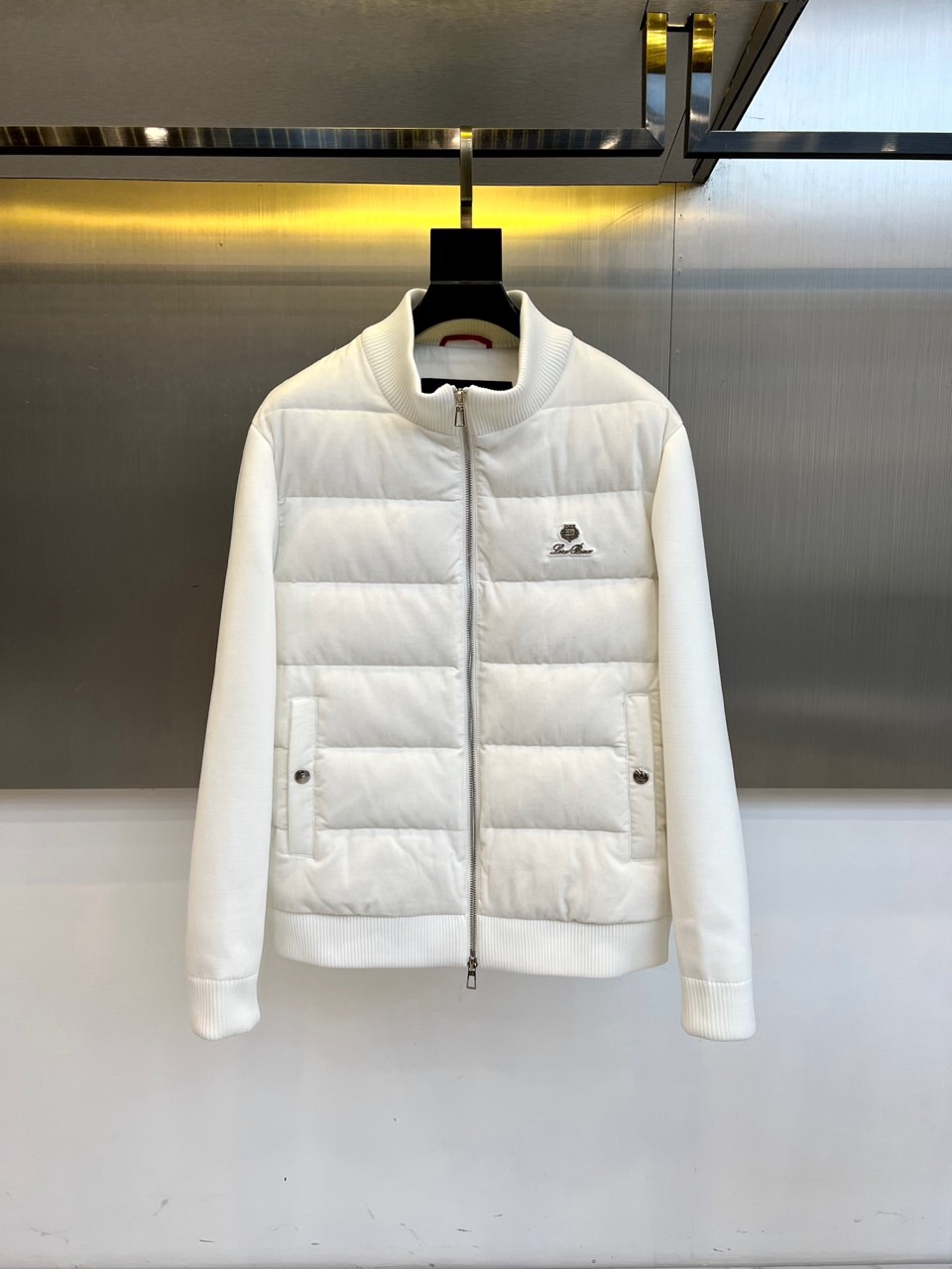 NO:600844,Loro Piana's new down jacket for autumn and winter 2025 interprets high-end outdoor aesthetics with minimalism. The style adopts a stand-up collar design with a smooth silver zipper, the brand's iconic logo is embellished on the left chest, and practical pockets with buttons are symmetrically designed on both sides. The cuffs and hem are ribbed to enhance warmth and fit.  Its design combines Alpine genes with modern urban style. It can be paired with casual trousers to create a daily look, and can also meet the needs of light outdoor activities. From urban commuting to outings in the suburbs, this down jacket, with its pure white tone and exquisite craftsmanship details, has become a winter model that connects high-end quality and practical functions, interpreting Loro Piana's ultimate pursuit of materials and craftsmanship. 48-56 (model 173, 143 pounds, upper body size 50),, loro piana, jacket, alexander wangdown19860909Loro Piana诺悠翩雅、2025秋冬新款羽绒服,以极简主义诠释高端户外美学.款式采用立领设计搭配顺滑银色拉链,左胸点缀品牌标志性徽标,两侧对称设计带纽扣的实用口袋.袖口与下摆采用罗纹收边工艺,增强保暖性能与贴合度. 其设计将阿尔卑斯山系基因与现代都市风格相融合,可搭配休闲长裤打造日常造型,亦能满足轻度户外活动需求.从城市通勤到郊外出行,这款羽绒服以纯净白色调与精湛工艺细节,成为连接高端品质与实用功能的冬季典范,诠释Loro Piana对材质与工艺的极致追求.48-56（模特173,143斤上身50码）,,loro piana,down jacket,alexander wang,Men's clothing