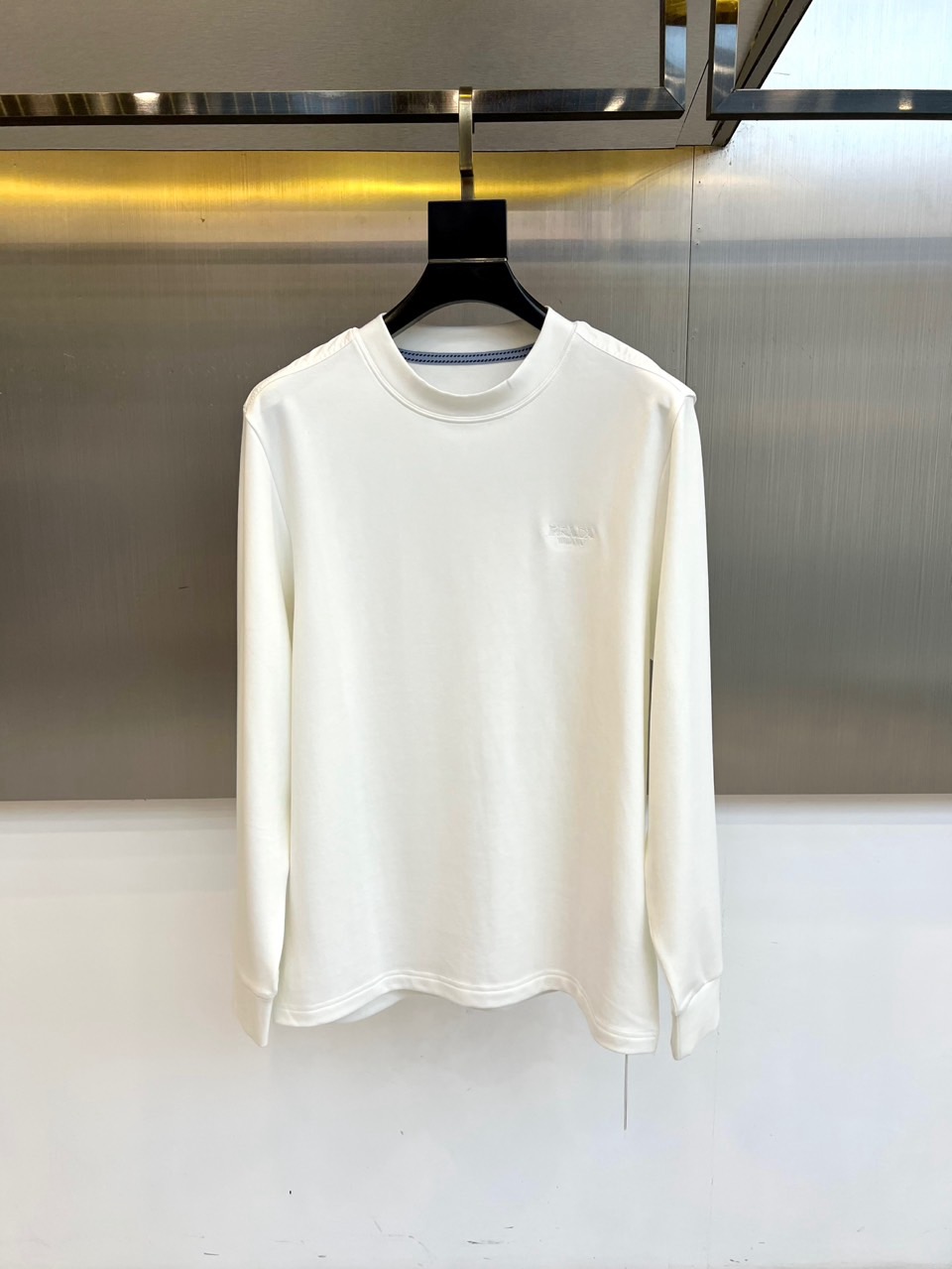 NO:600851,Prad, new product for autumn and winter 2025, P family-level craftsmanship air layer long-sleeved T-shirt. It is made of 47 cotton + 47 modal + 6 spandex in a scientific ratio. The 320g air layer fabric achieves the perfect balance of breathability and warmth through a double-layer structure. The round neck design is lined with blue and white pinstripe details, and the left chest is embellished with an exquisite brand-style embroidery logo. The neckline uses a double-needle crimping process to ensure that it does not deform.  Continuing the minimalist aesthetic, the modal material gives a velvet-like touch against the skin, and the spandex provides four-way elastic freedom of movement. When worn alone, it can be paired with casual pants to show an urban simple style. As an inner layer, it can enhance the layering through the collar stripe details. It interprets the design concept of integrating high-end craftsmanship with modern practicality. M-4XL (model 173,143 pounds upper body size L),, prada, prada, tees, t-shirt, alexander wang19860909Prad普拉、2025秋冬新品 P家级工艺空气层长袖T恤. 采用47棉+47莫代尔+6氨纶科学配比,320g空气层面料通过双层结构实现透气性与保暖性的完美平衡.圆领设计内衬蓝白细条纹细节,左胸点缀精致品牌风格刺绣标识,领口采用双针压线工艺确保不变形. 延续极简美学,莫代尔材质赋予丝绒般亲肤触感,氨纶提供四向弹性活动自由度.单穿时可搭配休闲裤展现都市简约风,作为内搭能通过领口条纹细节提升层次感.诠释将高端工艺与现代实穿性相融合的设计理念.M-4XL（模特173,143斤上身L码）,,prada,prada,tees，t-shirt,alexander wang,Men's clothing