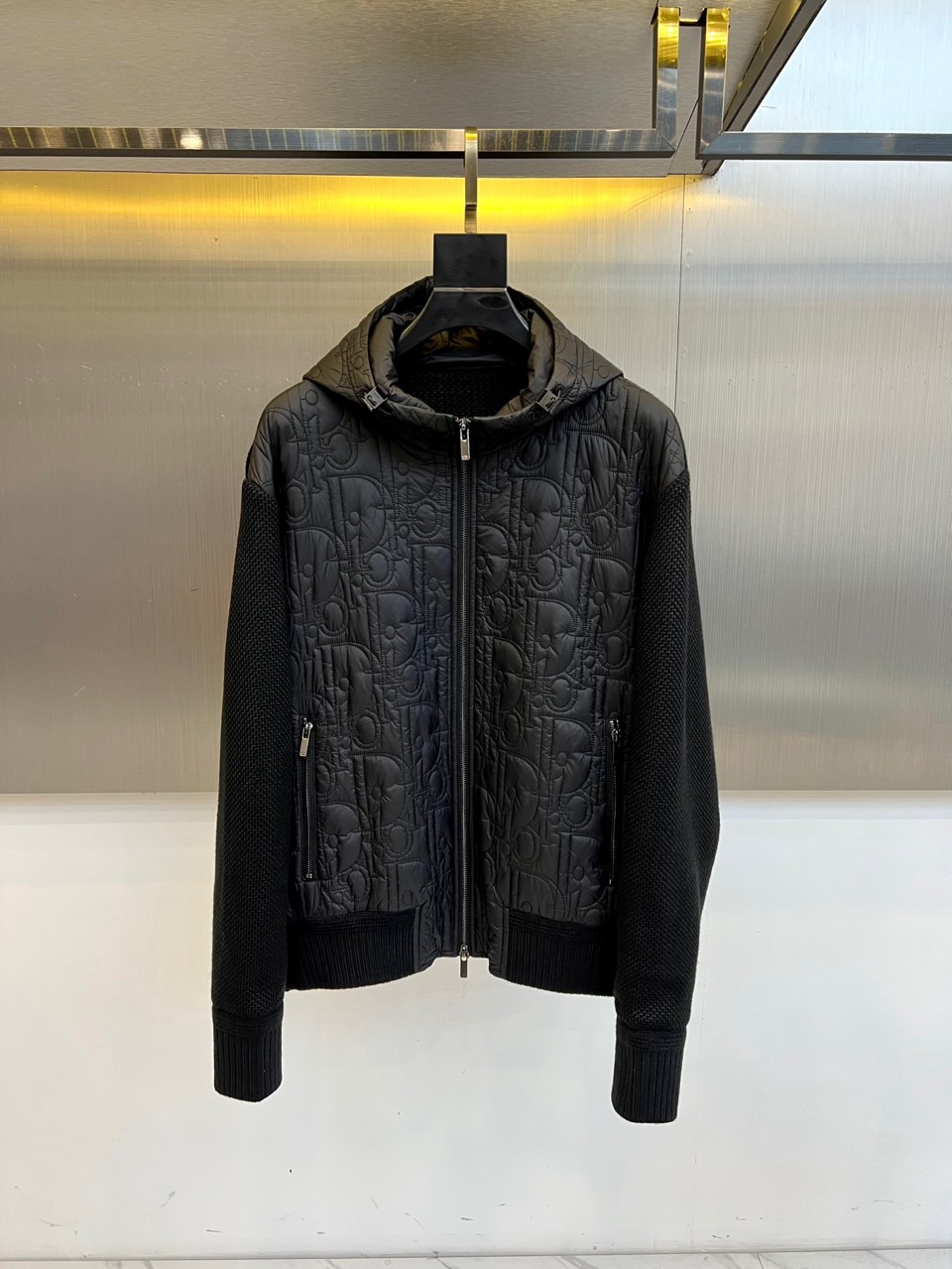 NO:600868,Dior Dior, 2025 autumn and winter new knitted patchwork cotton clothing, uses the collision of innovative materials to interpret modern functional aesthetics. The style adopts a hooded design with smooth zipper opening and closing, and the body is covered with the brand's iconic Oblique printed quilting pattern, through three-dimensional pressing  The thread craftsmanship creates a relief-like texture. The sleeves are made of 88 acrylic blended knitted fabric, which contrasts with the nylon woven body, which not only ensures the freedom of movement of the arms, but also enhances the visual hierarchy. It is equipped with practical pockets with zippers on both sides, and the cuffs are made of elastic hemming technology.  The fabric strictly follows the GB/T2662-2017 implementation standard. The woven main body is made of nylon material to ensure windproof performance, and the knitted part is blended with 10.8 polyester fiber and 1.2 spandex to enhance elasticity. The inner lining adopts a double-layer fabric system, lining 1 is a nylon breathable layer, lining 2 is a polyester fiber thermal layer, and filled with polyester fiber to ensure lightness and warmth. The safety category complies with GB18401-2010 Class C standard.  Its design combines classic presbyopic genes with sports functions. It can be paired with leather bottoms to create an urban mix-and-match style, or it can be combined with casual pants for daily commuting. From urban walks to suburban outings, this cotton jacket uses the ingenuity of material splicing and technical fabric performance to become an autumn and winter model that connects high-end fashion and pragmatism, interpreting Dior's contemporary reconstruction of traditional symbols. 48-56 (model 173, 143 pounds, upper body size 50),, dior, dior, hats, alexander wang19860909Dior迪奥、2025秋冬新品针织拼接棉服,以创新材质碰撞诠释现代机能美学.款式采用连帽设计搭配顺滑拉链开合,衣身满铺品牌标志性Oblique印花绗缝图案,通过立体压线工艺形成浮雕般质感.袖部采用88腈纶混纺针织面料,与锦纶梭织衣身形成材质对比,既保证臂部活动自由度,又强化视觉层次.两侧配备带拉链的实用插袋,袖口采用弹性收边工艺. 面料严格遵循GB/T2662-2017执行标准,梭织主体采用锦纶材质确保防风性能,针织部分融入10.8聚酯纤维与1.2氨纶增强弹性.内里采用双层面料系统,里料1为锦纶透气层,里料2为聚酯纤维保暖层,填充聚酯纤维确保轻盈保暖性.安全类别符合GB18401-2010 C类标准. 其设计将经典老花基因与运动功能相融合,可搭配皮革下装打造都市混搭风,亦可与休闲裤组合适应日常通勤.从城市漫步到郊外出行,这款棉服以材质拼接的巧思与科技面料性能,成为连接高端时装与实用主义的秋冬典范,诠释Dior对传统符号的当代重构.48-56（模特173,143斤上身50码）,,dior,dior,hats,alexander wang,Men's clothing