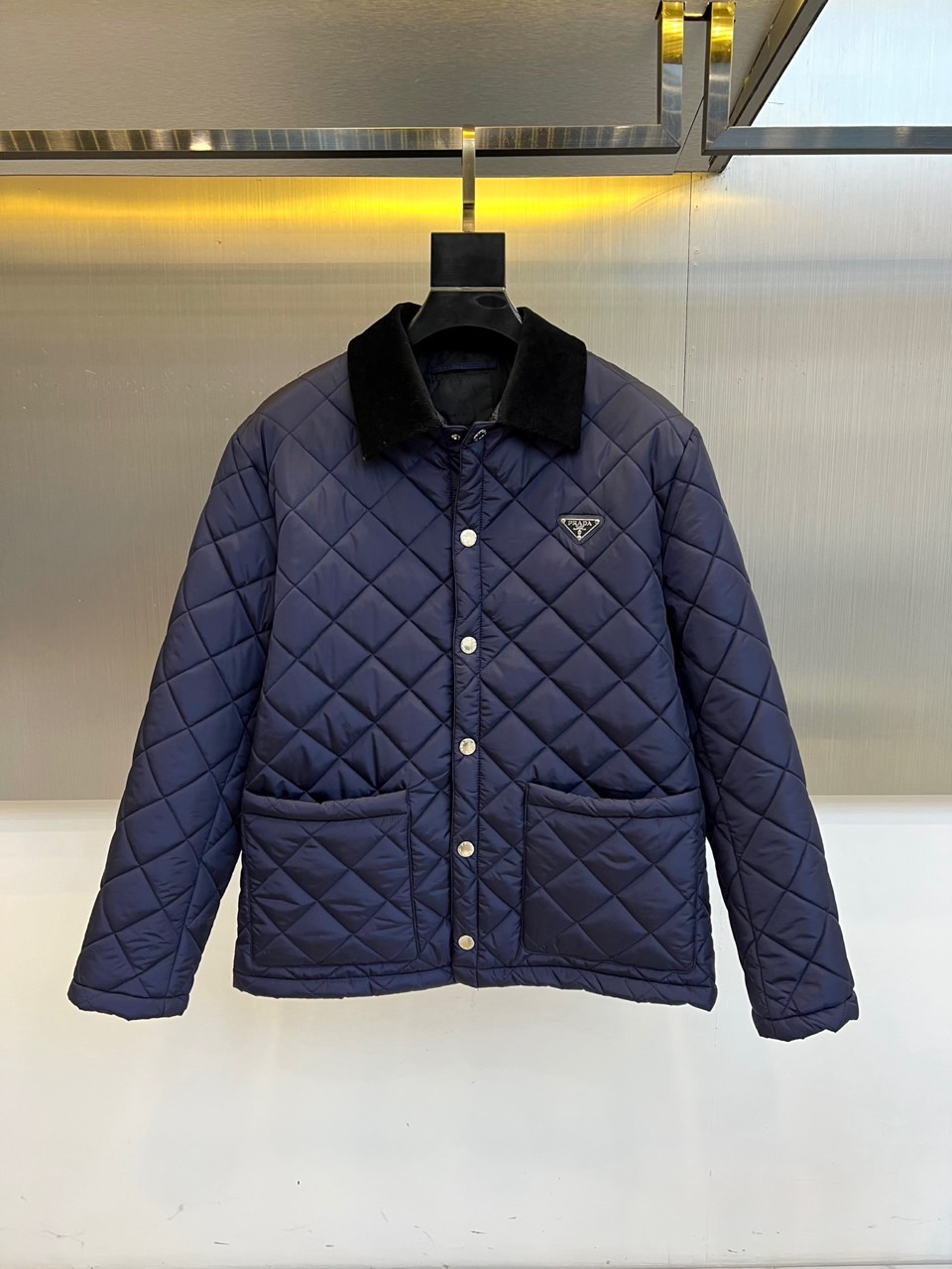 p430 Prad普拉达、2025秋冬新品棉服以经典菱格绗缝工艺重塑都市保暖美学。这款棉服采用立体翻领设计,内衬选用丝绒质感面料提升穿着舒适度。衣襟配备哑光金属按扣闭合系统,左侧胸口点缀标志性珐琅三角徽标,袖口采用罗纹收口设计防风保暖。填充高品质环保棉絮通过规整的菱形绗缝固定,既确保保暖性能又形成独特的立体纹理。
其剪裁融合修身与宽松的平衡感,双侧斜插口袋兼顾实用功能与线条流畅度。黑色面料表面呈现细微肌理变化,在光线折射下展现低调奢华感。从商务通勤到周末休闲,这款棉服能完美适配多种场合,既可搭配正装展现干练气质,也能结合休闲服饰营造轻松氛围。
细节处体现意式匠心,如精准的走线工艺与品牌标识的细腻铸造。它将实用主义与高级时装语言相融合,通过极简设计诠释永恒经典的冬季造型,成为追求品质生活的都市人士衣橱中不可或缺的时尚单品。48-56(模特173,143斤上身50码)