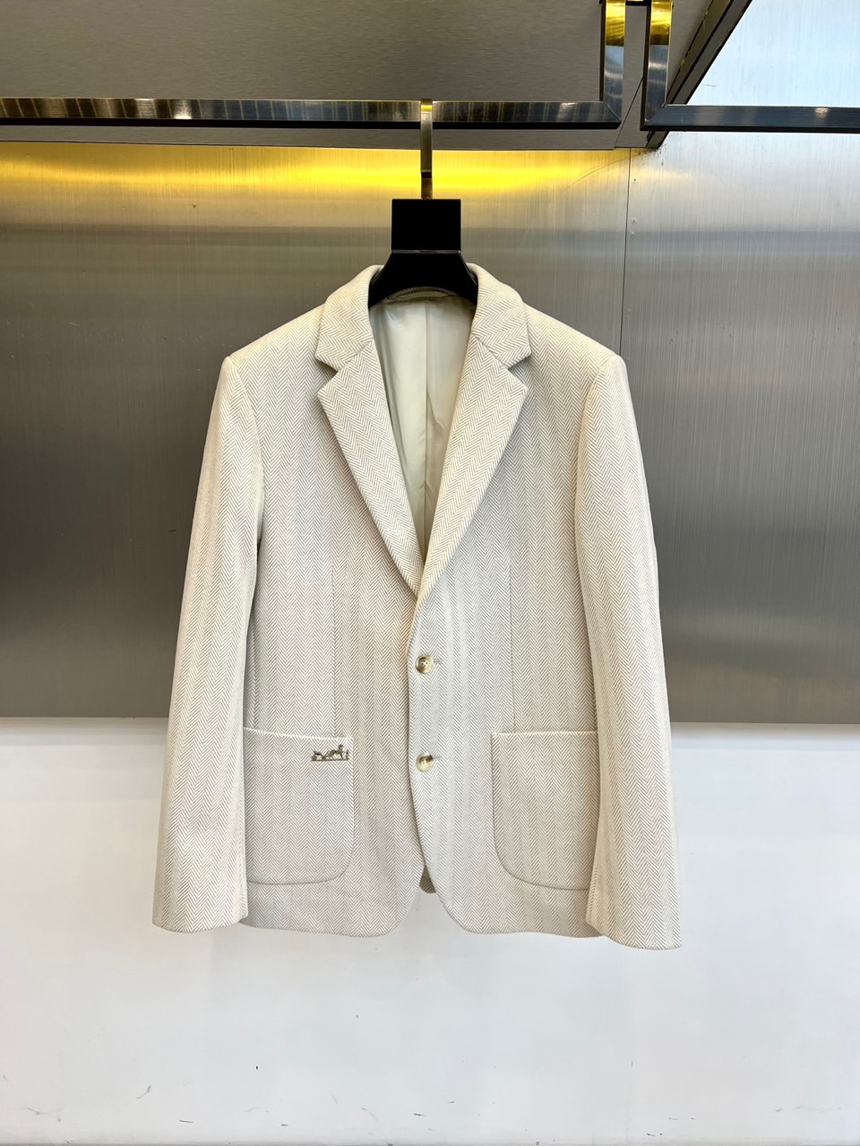 NO:608674,H Hermès, 2025 autumn and winter new wool suit, uses warm off-white color to interpret timeless elegance. This suit is made of worsted wool material with delicate herringbone texture. It has a single-breasted double-button design with neat lapels, which outlines the straight shoulder lines. Left chest  The bag is embellished with the brand's exquisite hand-embroidered logo, and the diagonal pockets on both sides are precisely cut to maintain a smooth silhouette. The lining is made of silky material to enhance wearing comfort, and the buttons are polished with natural shell material. Its design perfectly combines traditional suit craftsmanship with modern comfort needs.  Beautiful fusion, the off-white tone highlights the gentle temperament, and the herringbone pattern adds three-dimensional layers. Whether it is paired with trousers from the same series to create a business look, or mixed with casual trousers to create a mixed style, it can show an effortless fashion attitude. From important business meetings to high-end social occasions, this suit uses Hermès' unique craftsmanship and low-key luxury, becoming a model for interpreting the style of a modern gentleman. 48-56 (model is 173, 143 pounds, upper body size 50), hermes, business  suit,alexander wang19860909H爱马仕、2025秋冬新品羊毛西服,以温润米白色演绎永恒优雅.这款西服采用精纺羊毛材质织就细腻人字纹肌理,单排双扣设计搭配利落翻领,勾勒出挺拔的肩部线条.左胸口袋点缀品牌精致手工刺绣标识,两侧斜插口袋以精准剪裁保持流畅轮廓.内衬选用丝滑材质提升穿着舒适度,纽扣采用天然贝壳材质打磨而成.其设计将传统西装工艺与现代舒适需求完美融合,米白色调彰显温润气质,人字纹路增添立体层次.无论是搭配同系列西裤打造商务造型,还是与休闲裤碰撞出混搭风格,都能展现举重若轻的时尚态度.从重要商务会晤到高端社交场合,这件西服以爱马仕独有的匠心工艺与低调奢华,成为诠释现代绅士风范的典范之作.48-56（模特173,143斤上身50码）,,hermes,business suit,alexander wang,Men's clothing