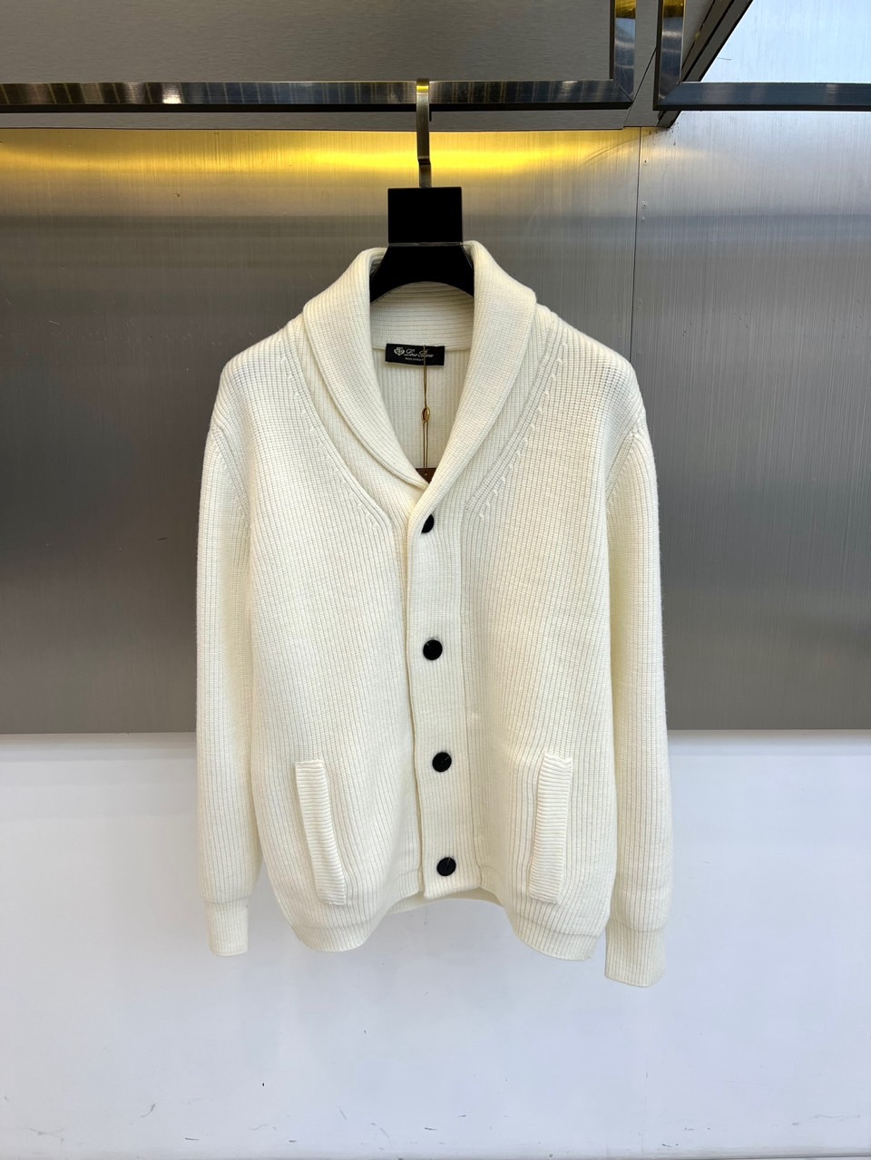 NO:608662,Loro  Piana's elegant, new 2025 autumn and winter knitted cardigan interprets timeless elegance with the ultimate fabric. This white cardigan adopts a smooth green fruit collar design, four black buttons embellish the placket, and practical pockets on both sides form a symmetrical aesthetic. Made of 70 wool and 30 wool  The golden ratio of velvet fabrics, the delicate knitted texture shows a soft luster under the light and shadow. Italian precision tailoring creates a loose yet stylish silhouette, and the ribbing edge technology ensures a long-lasting and stable version. Its design perfectly blends classic genes with modern comfort, and the green fruit collar has natural lines  The drape forms an elegant arc, and the contrasting black and white details highlight low-key luxury. From high-end business occasions to casual social gatherings, this cardigan can become a styling highlight with a texture that transcends seasons. The series also launches five classic colors: off-white, light gray, dark gray, navy blue and black.  Adjustable to meet different style needs. The label is clearly marked with Made in Italy and professional care guidelines, confirming the brand's persistent pursuit of quality, becoming a luxurious item that can be passed down in the autumn and winter wardrobe. 48-54 (model is 173, 143 pounds, upper body size 50),, loro  piana,gold,alexander wang19860909Loro Piana诺悠翩雅、2025秋冬新品针织开衫以极致面料诠释永恒优雅.这款白色开衫采用流畅的青果领设计,四颗黑色纽扣点缀门襟,与两侧实用口袋构成对称美学.采用70羊毛与30羊绒的黄金配比面料,细腻的针织肌理在光影下呈现柔和光泽.意大利精工剪裁打造宽松而不失型的廓形,罗纹收边工艺确保版型持久稳定.其设计将经典基因与现代舒适感完美融合,青果领线条自然垂坠形成优雅弧度,黑白对比的细节处理彰显低调奢华.从高级商务场合到休闲社交聚会,这件开衫都能以超越季节的质感成为造型亮点.系列同时推出米白、浅灰、深灰、藏蓝与黑色五款经典色调,满足不同风格需求.标签明确标注意大利制造与专业护理指南,印证品牌对品质的执着追求,成为秋冬衣橱中可传承的奢华单品.48-54（模特173,143斤上身50码）,,loro piana,gold,alexander wang,Men's clothing