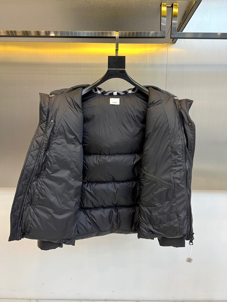 Bur巴宝莉、2025秋冬新品羽绒服以经典演绎英伦风尚，短款廓形搭配连帽设计，帽檐点缀品牌标志性格纹元素