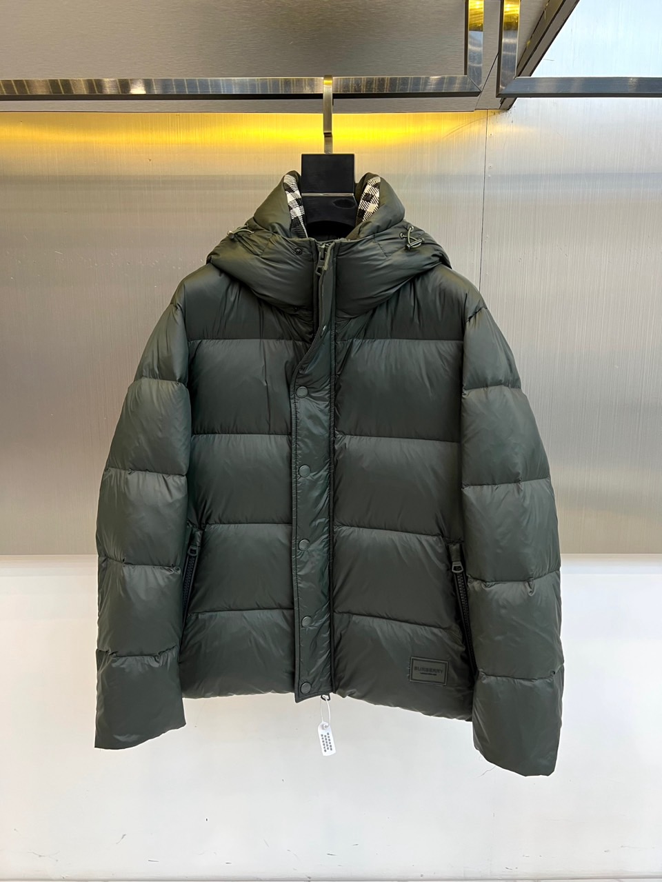 Bur巴宝莉、2025秋冬新品羽绒服以经典演绎英伦风尚，短款廓形搭配连帽设计，帽檐点缀品牌标志性格纹元素