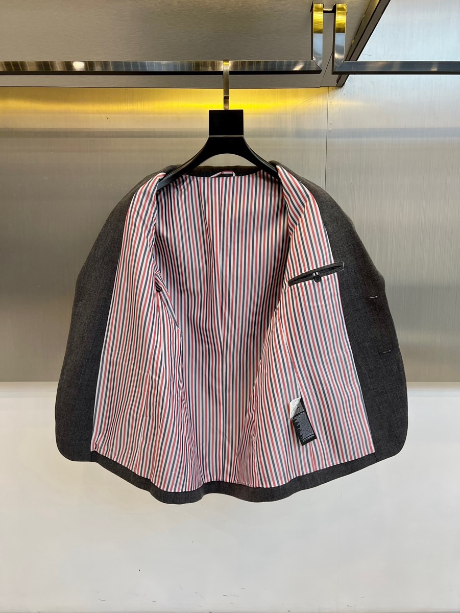 TB汤姆布朗、2025秋冬新品灰色休闲西装，这款西装采用单排两粒扣设计，左胸设有一个贴袋，下摆两侧各配立