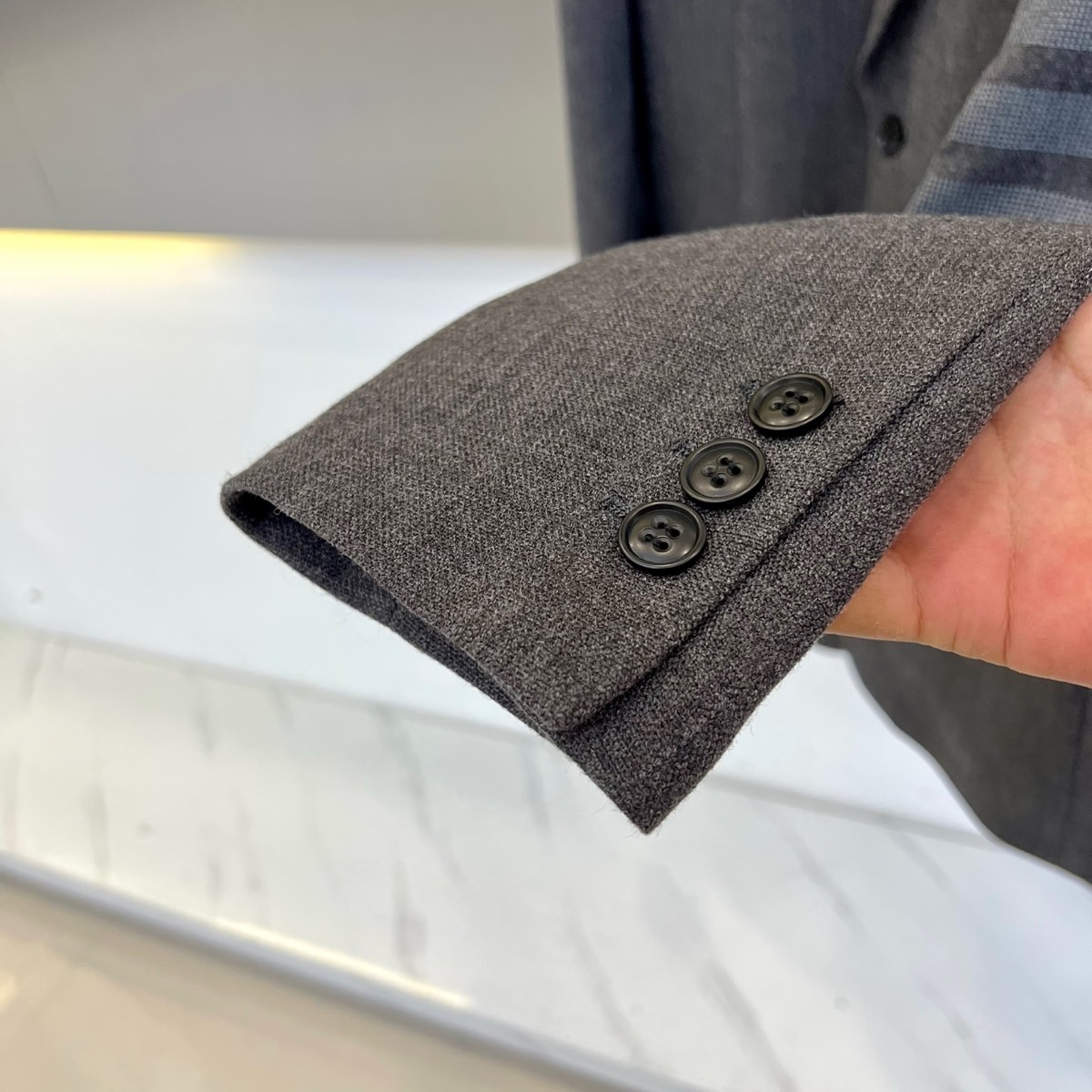 TB汤姆布朗、2025秋冬新品灰色休闲西装，这款西装采用单排两粒扣设计，左胸设有一个贴袋，下摆两侧各配立