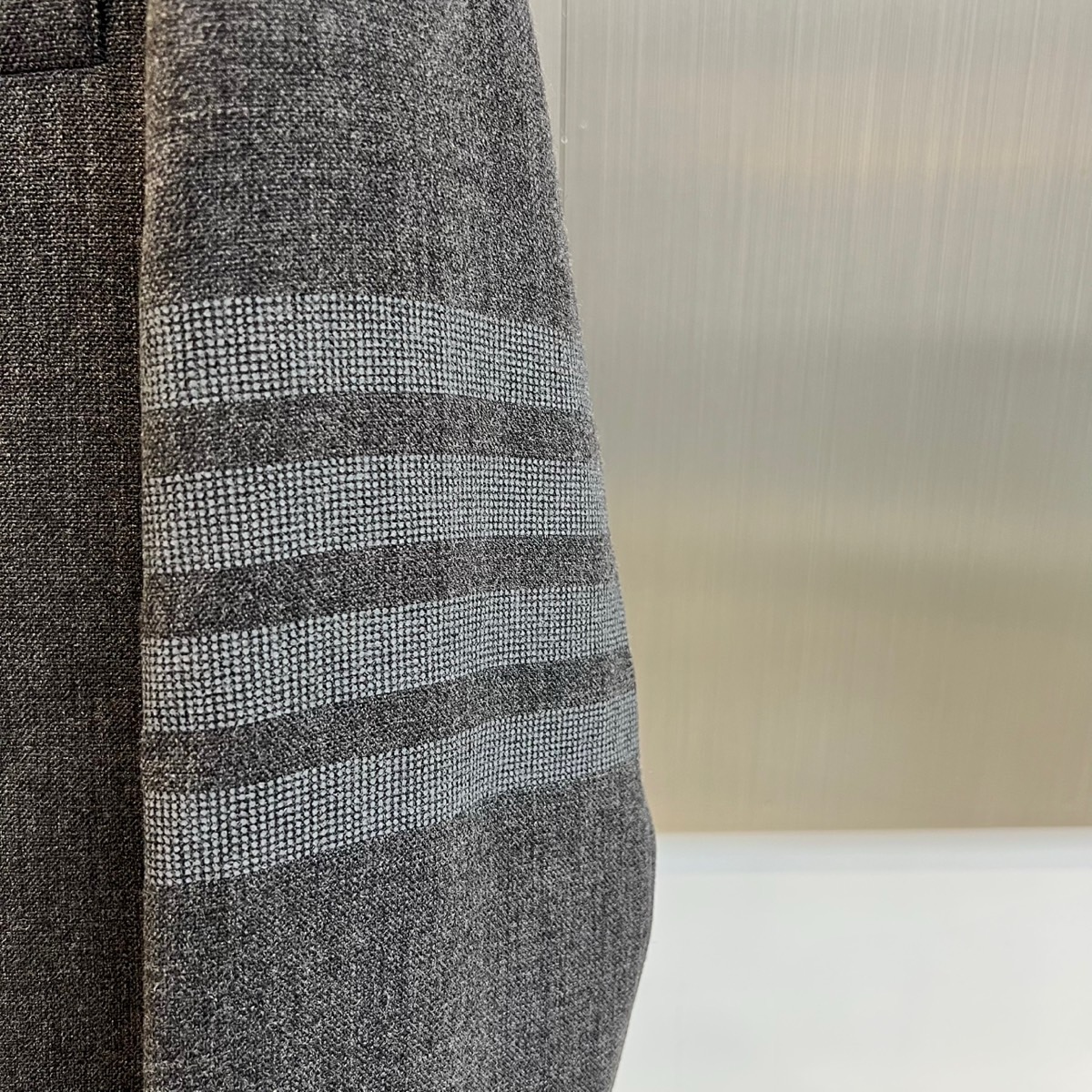 TB汤姆布朗、2025秋冬新品灰色休闲西装，这款西装采用单排两粒扣设计，左胸设有一个贴袋，下摆两侧各配立