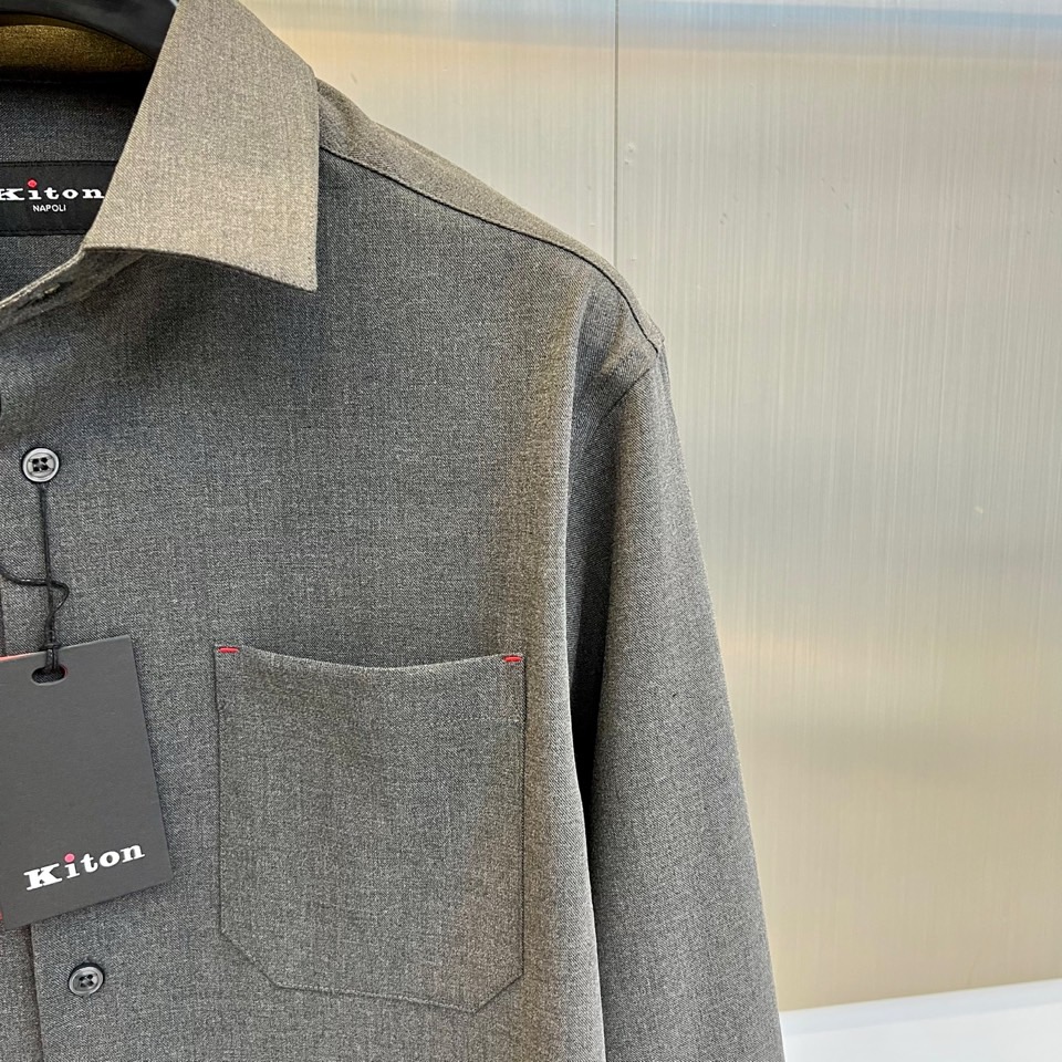 Kiton-2025秋冬新品匠心工艺衬衫。这款卡其色衬衫采用经典翻领设计，前襟搭配五颗天然母贝纽扣，左胸