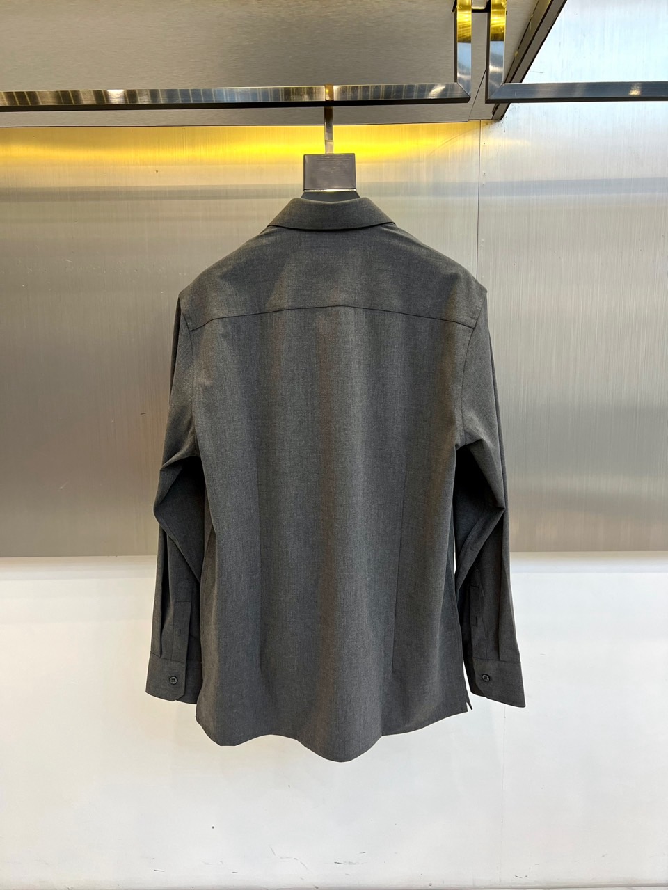 Kiton-2025秋冬新品匠心工艺衬衫。这款卡其色衬衫采用经典翻领设计，前襟搭配五颗天然母贝纽扣，左胸