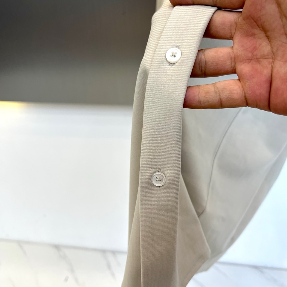 Kiton-2025秋冬新品匠心工艺衬衫。这款卡其色衬衫采用经典翻领设计，前襟搭配五颗天然母贝纽扣，左胸