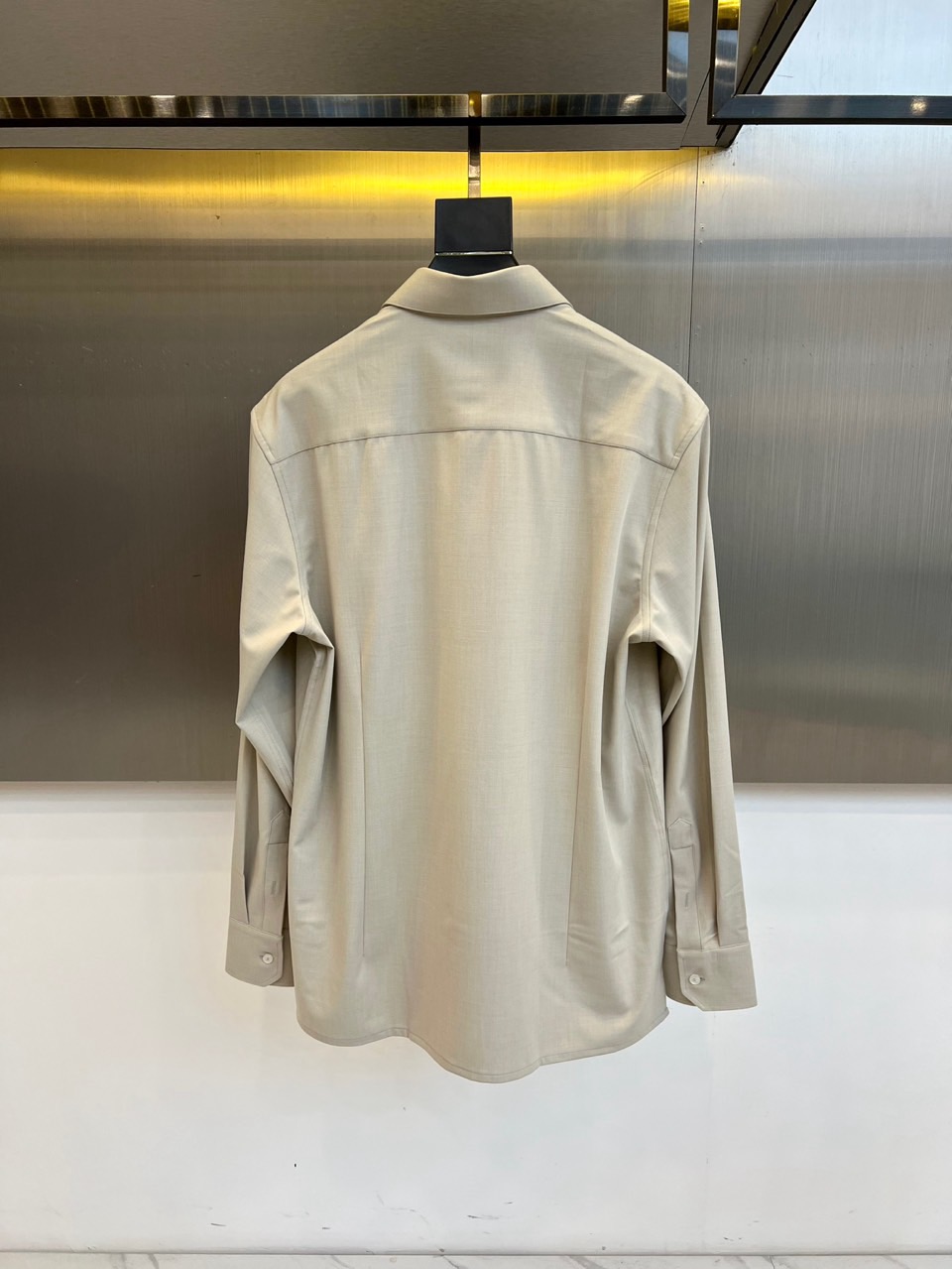 Kiton-2025秋冬新品匠心工艺衬衫。这款卡其色衬衫采用经典翻领设计，前襟搭配五颗天然母贝纽扣，左胸